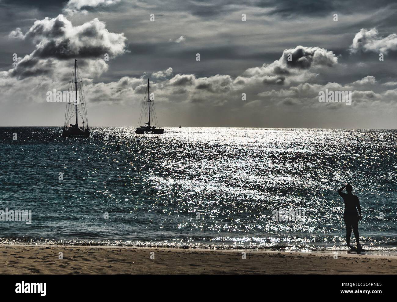 Coucher du soleil derrière les nuages sur une plage tropicale. Banque D'Images