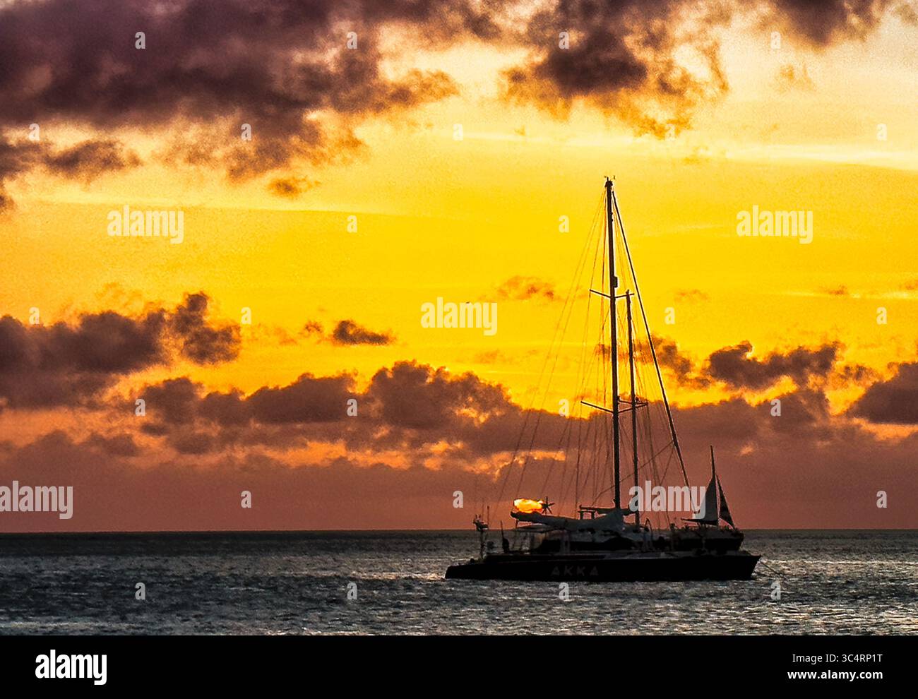 Les gens sur la plage comme le soleil se couche. Banque D'Images