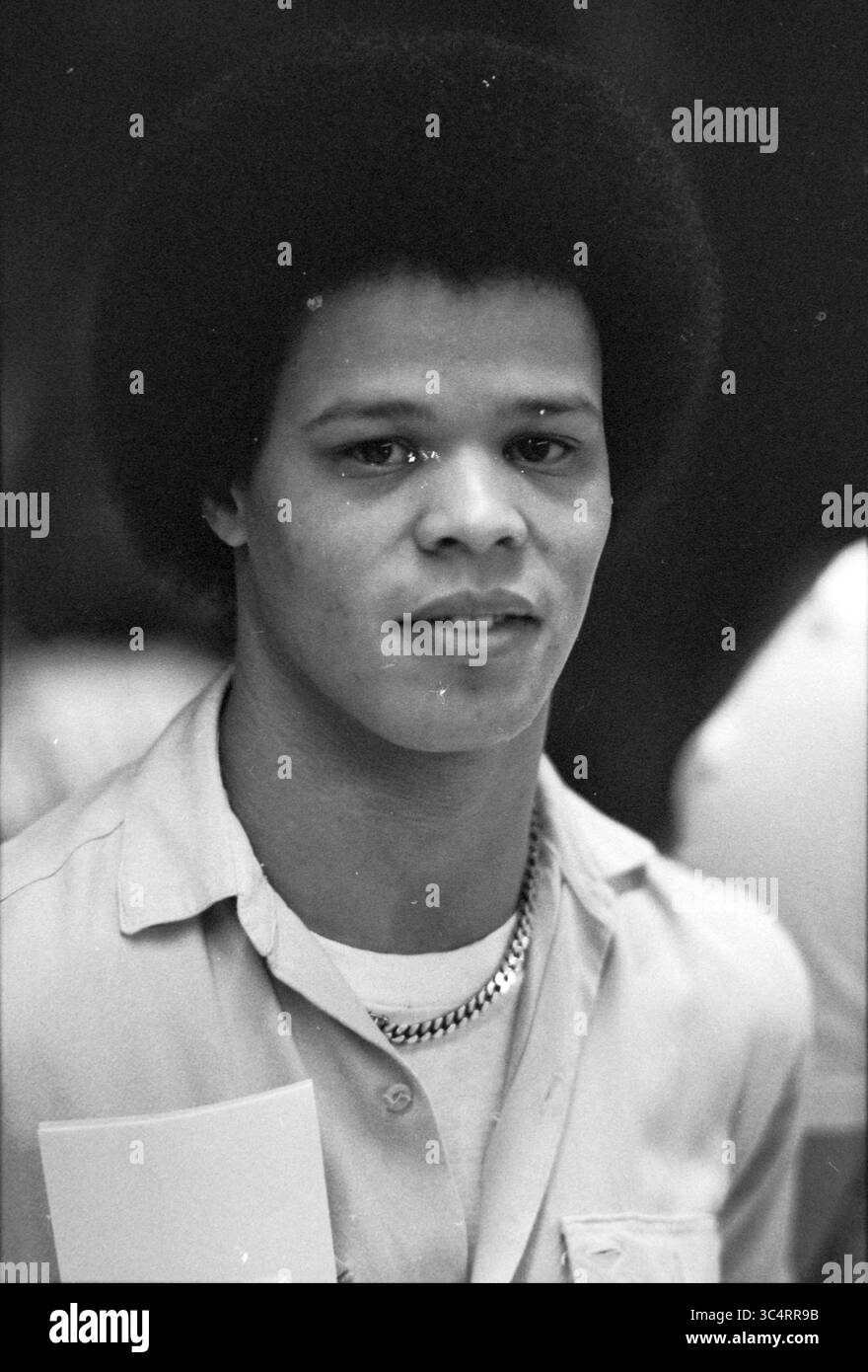 Water polo : Portrait Elly Spijker + coach KZC, KZC - OZ et PC, water polo, 13-02-1982 Whizgle News, Dutch Desk, pays-Bas, 1950-2000 Un jeune homme avec une coiffure afro se tient confiant, portant une chemise à col et un collier en chaîne, regardant directement le spectateur avec une expression calme. Banque D'Images Water polo : Portrait Elly Spijker + coach KZC, KZC - OZ et PC, water polo, 13-02-1982 Whizgle News, Dutch Desk, pays-Bas, 1950-2000 Un jeune homme avec une coiffure afro se tient confiant, portant une chemise à col et un collier en chaîne, regardant directement le spectateur avec une expression calme. Banque D'Images