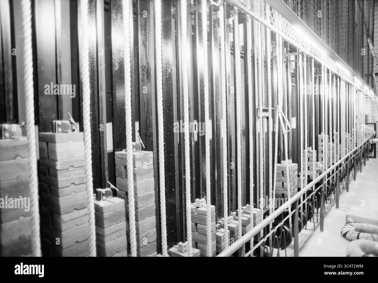 Théâtre urbain, scène, 20-08-1991 Whizgle News, Dutch Desk, pays-Bas, 1950-2000 Une série de piles de poids alignées contre un mur, reliées à un réseau de poulies et de câbles, suggérant un environnement de gymnastique ou de centre de fitness conçu pour la musculation. Banque D'Images