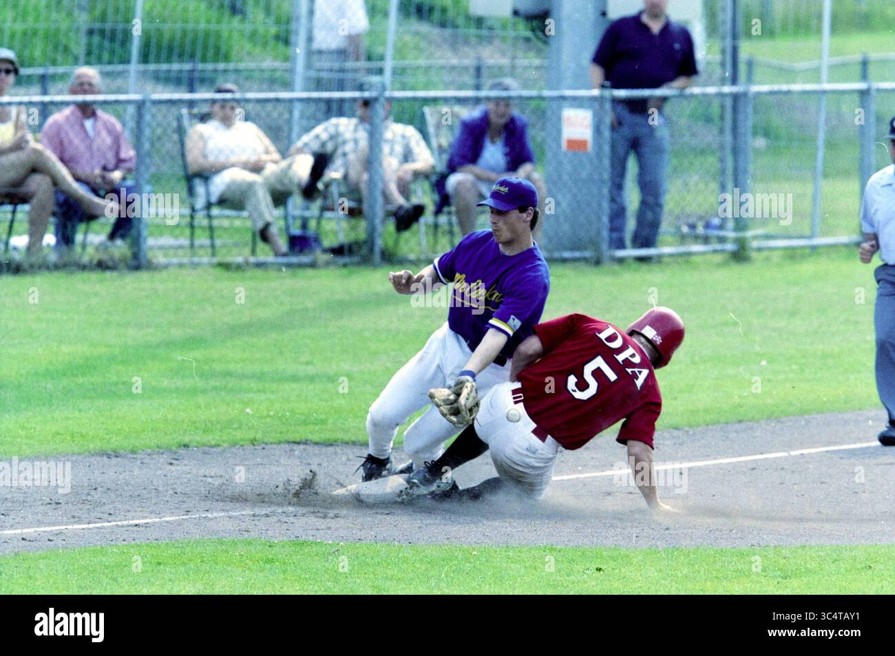 Baseball, Kinheim - HCAW, 23-06-2001 Whizgle News, Dutch Desk, pays-Bas, 1950-2000 Un joueur de baseball glisse dans la base, dégageant de la poussière alors qu'il tente d'éviter d'être étiqueté par un joueur défensif. En arrière-plan, les fans regardent attentivement depuis les lignes de touche, créant une atmosphère d'excitation et d'anticipation. Banque D'Images