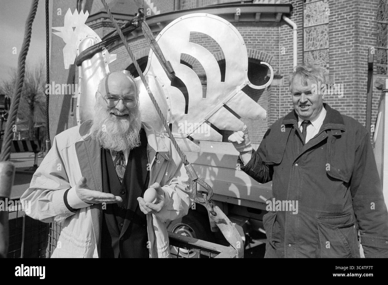 Coq sur la tour de l'église, le Zilk, de Zilk, 22-03-1991 Whizgle News, Dutch Desk, pays-Bas, 1950-2000 deux hommes sourient devant une grande sculpture en métal au design complexe représentant un coq stylisé. Un homme, avec une longue barbe blanche, fait des gestes ludiques tout en tenant un objet, tandis que l'autre homme se tient à côté de lui, mettant en valeur de façon désinvolte un morceau de la sculpture. Leurs expressions joyeuses capturent un moment de camaraderie et de créativité. Banque D'Images Coq sur la tour de l'église, le Zilk, de Zilk, 22-03-1991 Whizgle News, Dutch Desk, pays-Bas, 1950-2000 deux hommes sourient devant une grande sculpture en métal au design complexe représentant un coq stylisé. Un homme, avec une longue barbe blanche, fait des gestes ludiques tout en tenant un objet, tandis que l'autre homme se tient à côté de lui, mettant en valeur de façon désinvolte un morceau de la sculpture. Leurs expressions joyeuses capturent un moment de camaraderie et de créativité. Banque D'Images