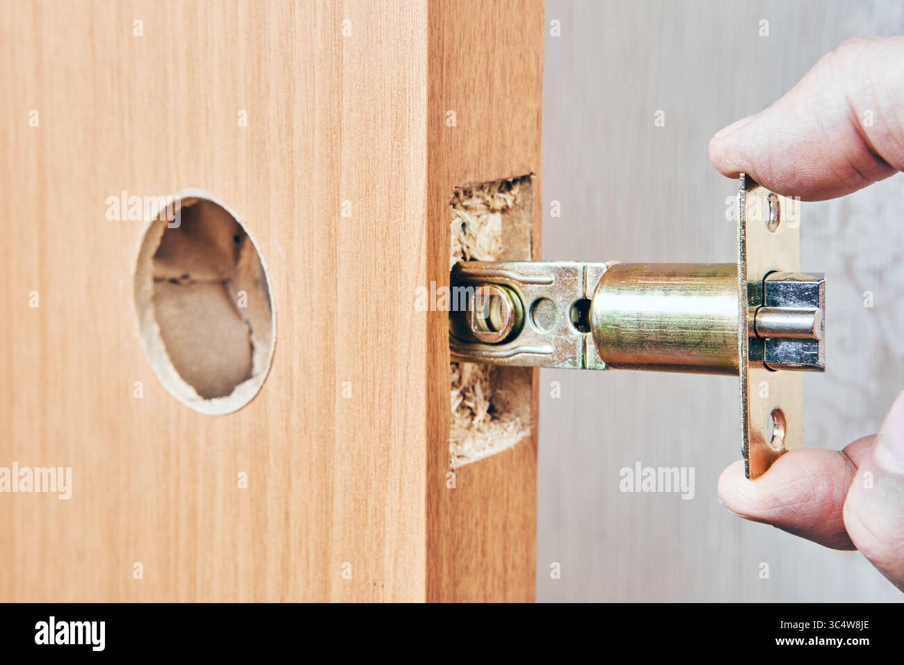 Mécanisme de verrouillage inséré dans le trou prédécoupé sur le bord de la porte aligné avec l'alésage rond pour l'installation ultérieure du bouton et la fonction de verrouillage. Banque D'Images