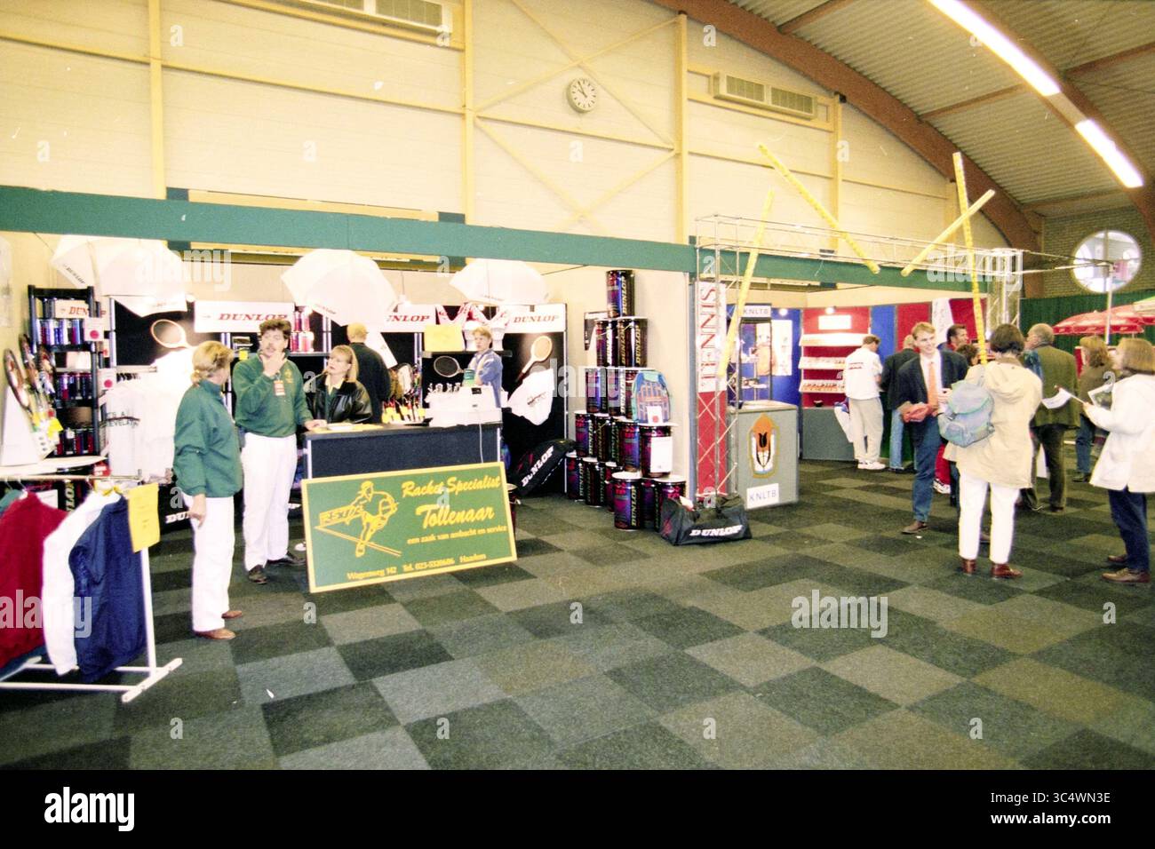Tennis en fauteuil roulant dans la salle des sports avec festivités dans le hall, 00-09-1996 Whizgle News, Dutch Desk, pays-Bas, 1950-2000 Une exposition animée présentant divers stands de fournisseurs, présentant des équipements sportifs et du matériel promotionnel. Les participants s'engagent avec les présentoirs et interagissent avec le personnel, tandis que des bannières et des marchandises colorées remplissent l'espace. Banque D'Images