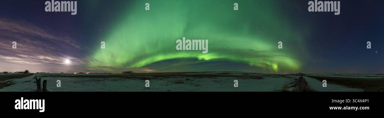 20 avril 2018 - Alberta, Canada - Un panorama de 220Â°Â de l'ouest (gauche) à l'est (droite) de l'aurore lumineuse dans un arc classique à travers le nord, le 19 avril 2019. C'était à partir d'un retrait en bordure de route sur la route 564 au nord de Strathmore, en Alberta. ..le croissant de lune cireux se couche à gauche dans le nord-ouest ; Jupiter se lève à l'extrême droite dans le sud-est. Les lumières de Calgary éclairent le ciel et les nuages à l'extrême gauche... il s'agit d'un panorama de 10 sections cousu avec Camera Raw. Toutes les expositions de 8 secondes à f/2,8 avec l'objectif Sigma 24mm Art et Nikon D750 à 1600 ISO. (Crédit image : © Alan Dyer / Vwpics/VW pic Banque D'Images