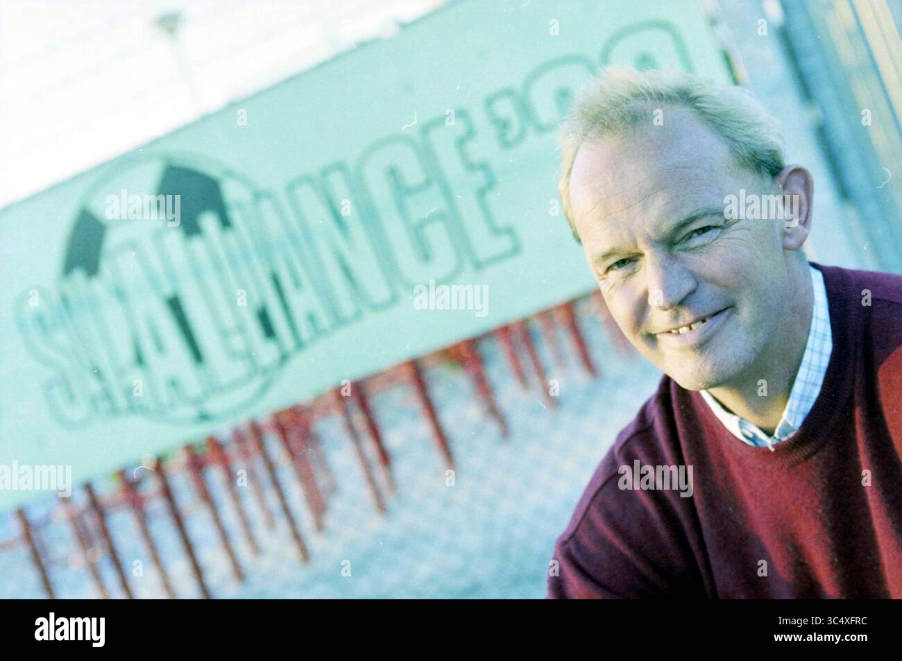 Joop van Velsen, Alliance, Haarlem, pays-Bas, 25-03-2003 Whizgle News, Dutch Desk, pays-Bas, 1950-2000 Un individu souriant pose avec confiance devant un décor animé sur le thème du football, mettant en avant un sentiment de communauté et d'enthousiasme pour ce sport. Banque D'Images