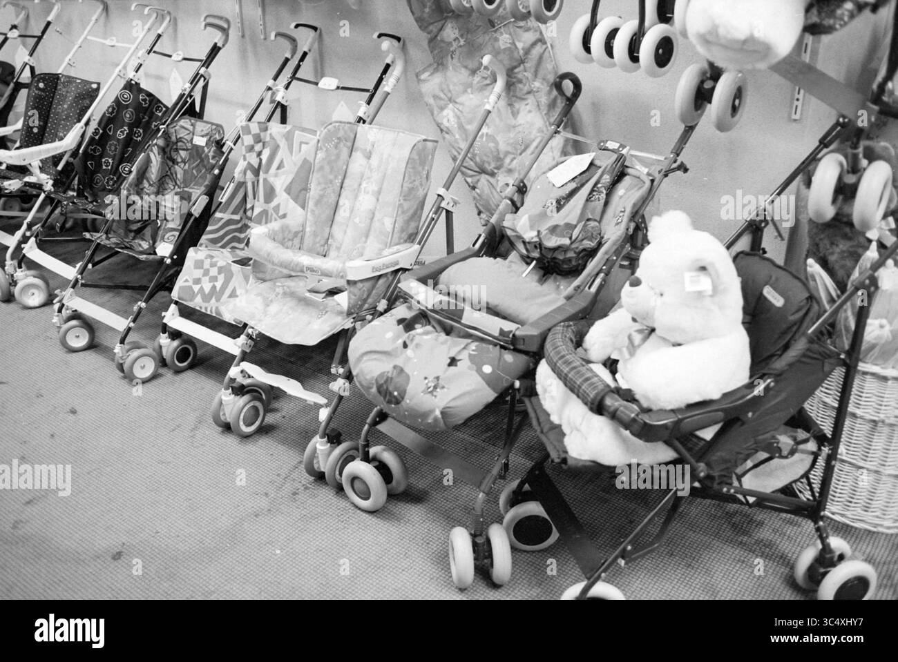 Baby shop Gardo, Haarlem, pays-Bas, 05-10-1994 Whizgle News, Dutch Desk, pays-Bas, 1950-2000 Une rangée de poussettes pour enfants de différents styles et couleurs, alignées soigneusement contre un mur. Certaines poussettes présentent des motifs ludiques, tandis que d'autres ont des jouets en peluche assis en eux, ajoutant une touche fantaisiste à l'affichage. Banque D'Images