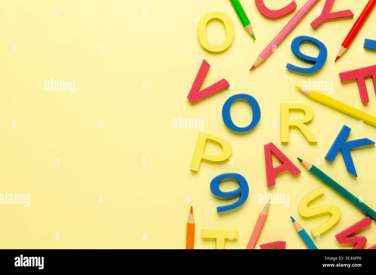 Lettres colorées en mousse, chiffres et crayons sur fond jaune avec espace de copie. Banque D'Images Lettres colorées en mousse, chiffres et crayons sur fond jaune avec espace de copie. Banque D'Images