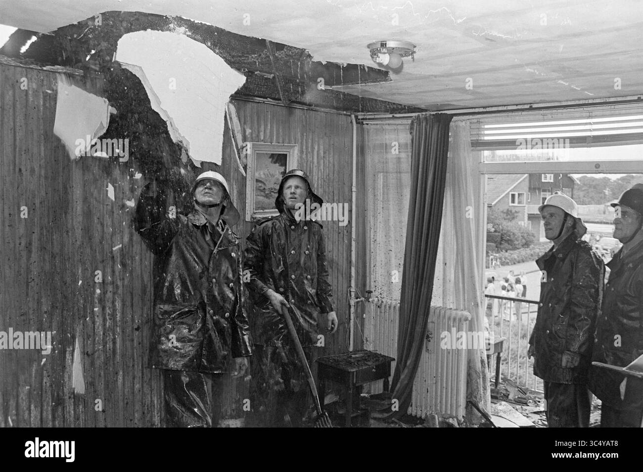 Brand Dr. Schaepmanlaan, Heemstede, incendies, pompiers, Heemstede, Dr Schaepmanlaan, pays-Bas, 02-08-1974 Whizgle News, Dutch Desk, pays-Bas, 1950-2000 Un groupe de pompiers examine un plafond endommagé dans une salle de séjour, avec du plâtre écaillé et des taches d'eau évidentes. Un pompier pointe vers le plafond tandis que d'autres se tiennent debout, évaluant la situation au milieu de signes de dégâts d'eau. Banque D'Images