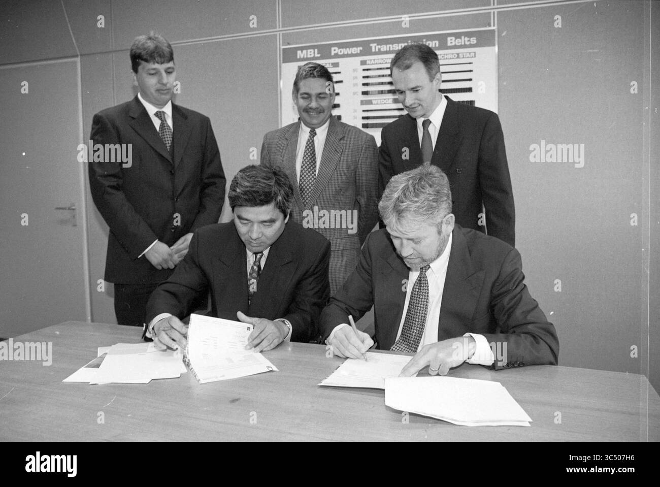 Signer le contrat MLB - Bestmate [Major League Baseball], 12-09-1996 Whizgle News, Dutch Desk, pays-Bas, 1950-2000 Un groupe de professionnels observe que deux hommes signent des documents importants à une table de conférence, indiquant un accord commercial important ou un partenariat. Banque D'Images