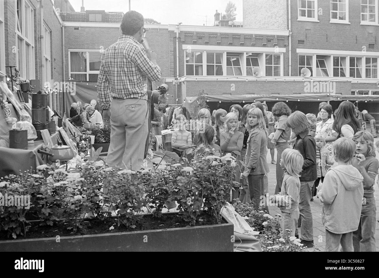 Ouverture du clubhouse-aire de jeux à Overveen., ouverture, ouvertures, mise en service, 14-09-1974 Whizgle News, Dutch Desk, pays-Bas, 1950-2000 Un artiste divertit un groupe d'enfants lors d'un événement communautaire, tandis que des adultes regardent depuis l'arrière-plan. Les décorations colorées et les plantes ajoutent une atmosphère festive à la réunion. Banque D'Images Ouverture du clubhouse-aire de jeux à Overveen., ouverture, ouvertures, mise en service, 14-09-1974 Whizgle News, Dutch Desk, pays-Bas, 1950-2000 Un artiste divertit un groupe d'enfants lors d'un événement communautaire, tandis que des adultes regardent depuis l'arrière-plan. Les décorations colorées et les plantes ajoutent une atmosphère festive à la réunion. Banque D'Images