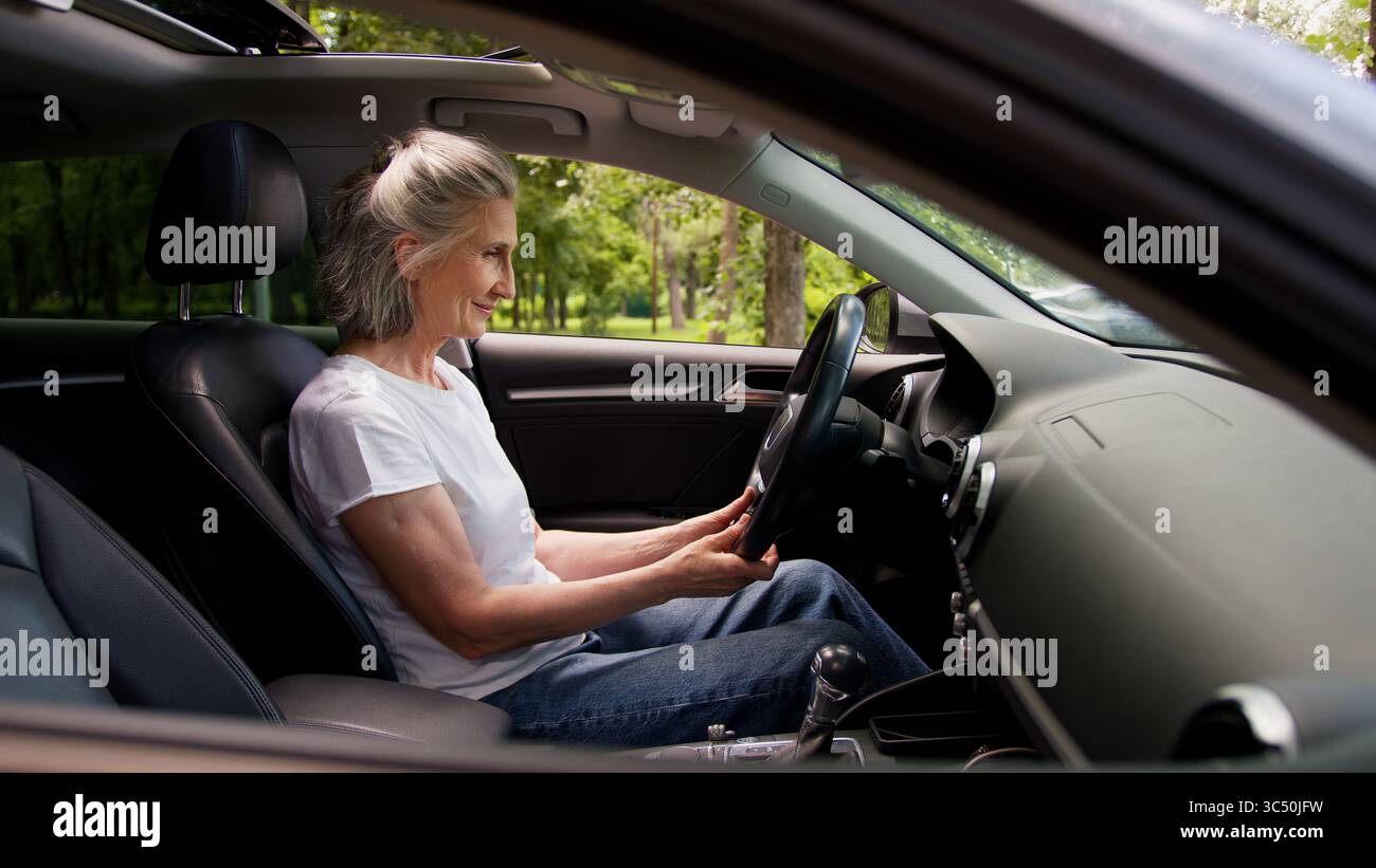 Heureux excité femme âgée caucasienne femme grand-mère voiture conducteur de location de service client de véhicule acheteur à l'intérieur de l'automobile célébrer l'auto d'achat Banque D'Images