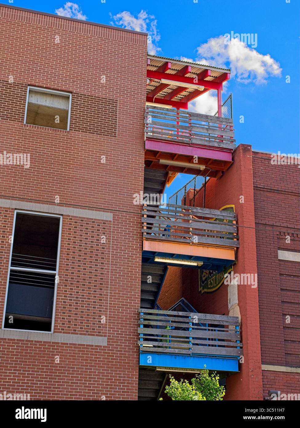 Paliers d'escalier extérieur colorés entre deux bâtiments en briques Banque D'Images