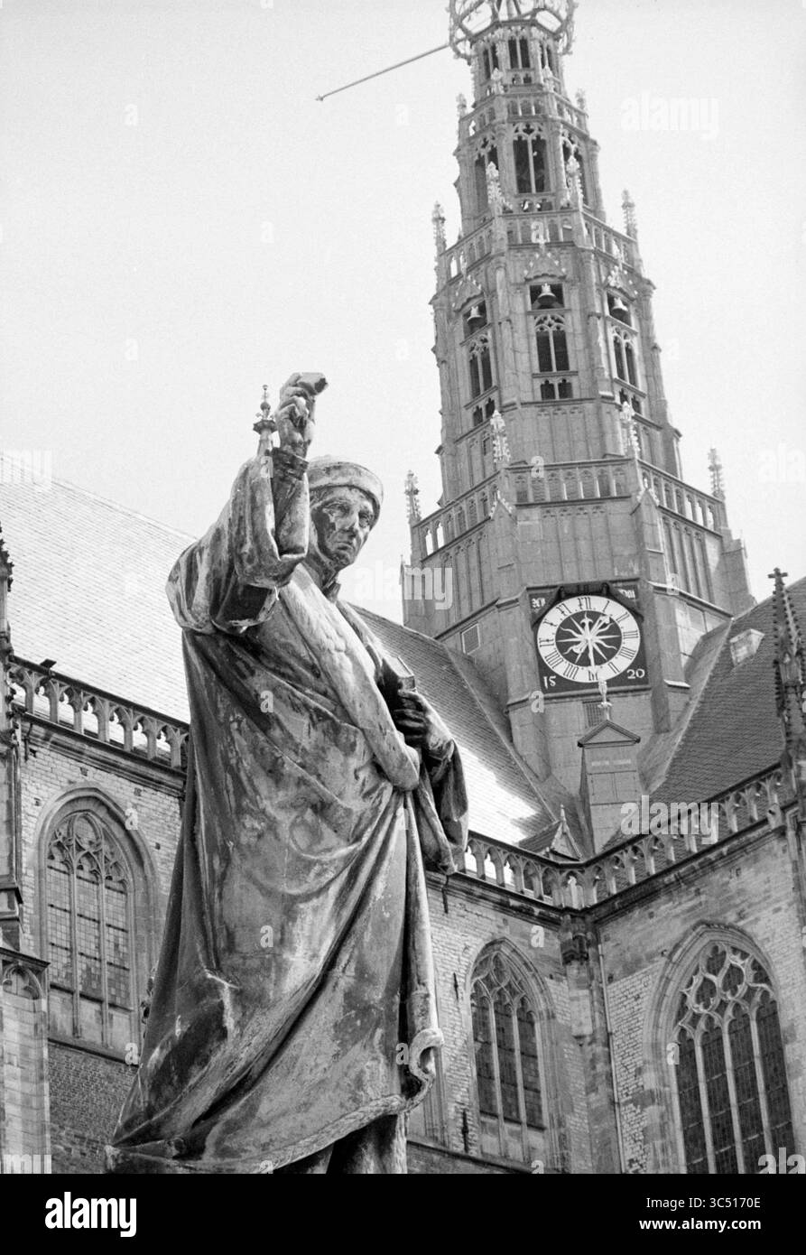 Rapport Loutje, Grote Markt, Report, Haarlem, Grote Markt, pays-Bas, 09-08-1972 Whizgle News, Dutch Desk, pays-Bas, 1950-2000 Une statue historique se dresse bien en vue devant une grande église, avec une grande tour de l'horloge derrière elle affichant l'heure. L'architecture complexe du bâtiment présente des toits pointus et des sculptures détaillées, créant une toile de fond saisissante pour la figure qui se déplace vers le haut. Banque D'Images