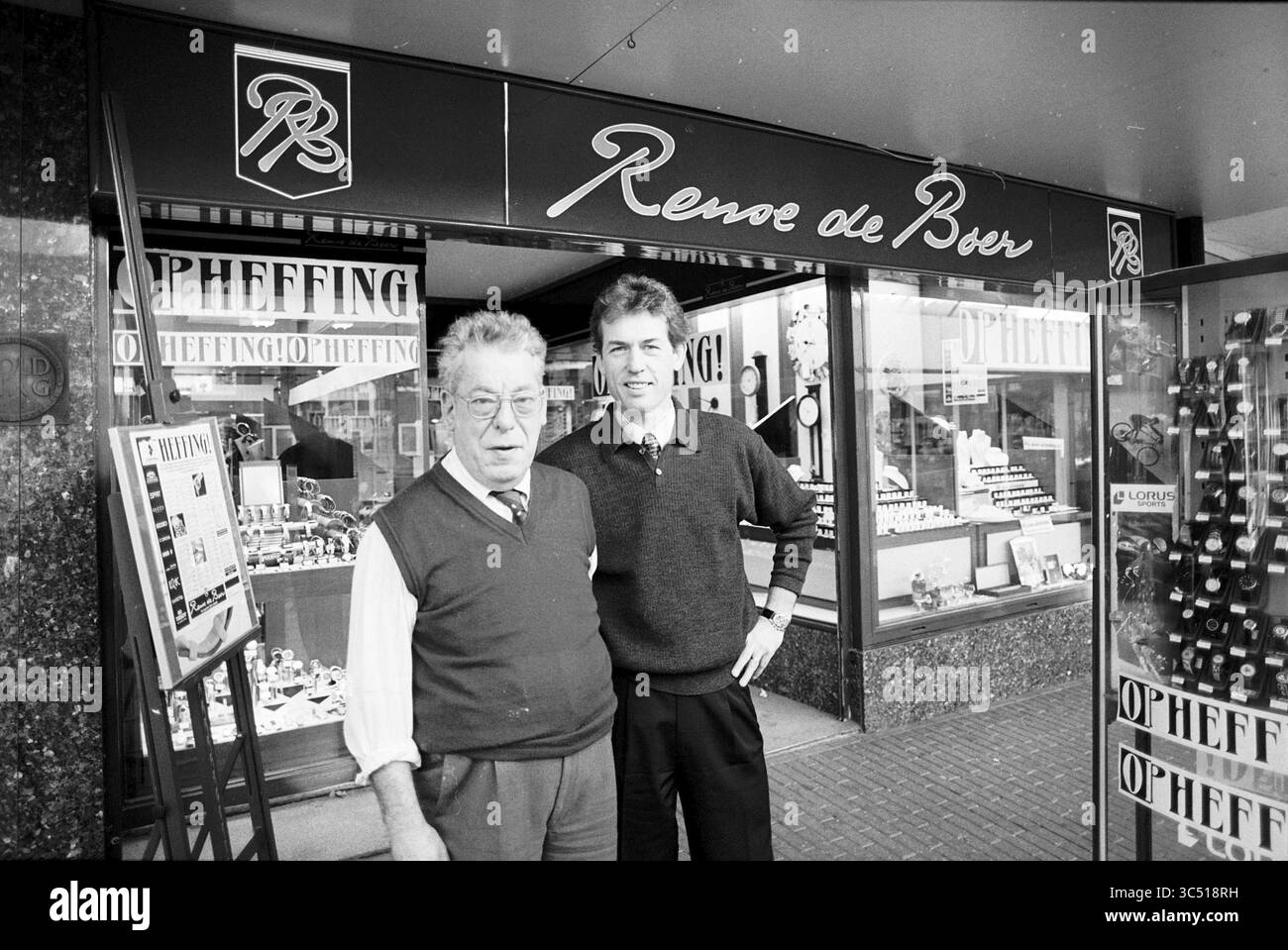 Bijoutier de Boer en relation avec la fermeture, IJmuiden, IJmuiden, pays-Bas, 30-10-1997 Whizgle News, Dutch Desk, pays-Bas, 1950-2000 deux hommes se tiennent devant une bijouterie, souriant à la caméra. La signalétique de la boutique porte le nom de « Renee de Boer », et les vitrines présentent une variété de montres et de bijoux. L'homme le plus âgé porte des lunettes et un gilet, tandis que le plus jeune porte un pull et une tenue décontractée. Banque D'Images