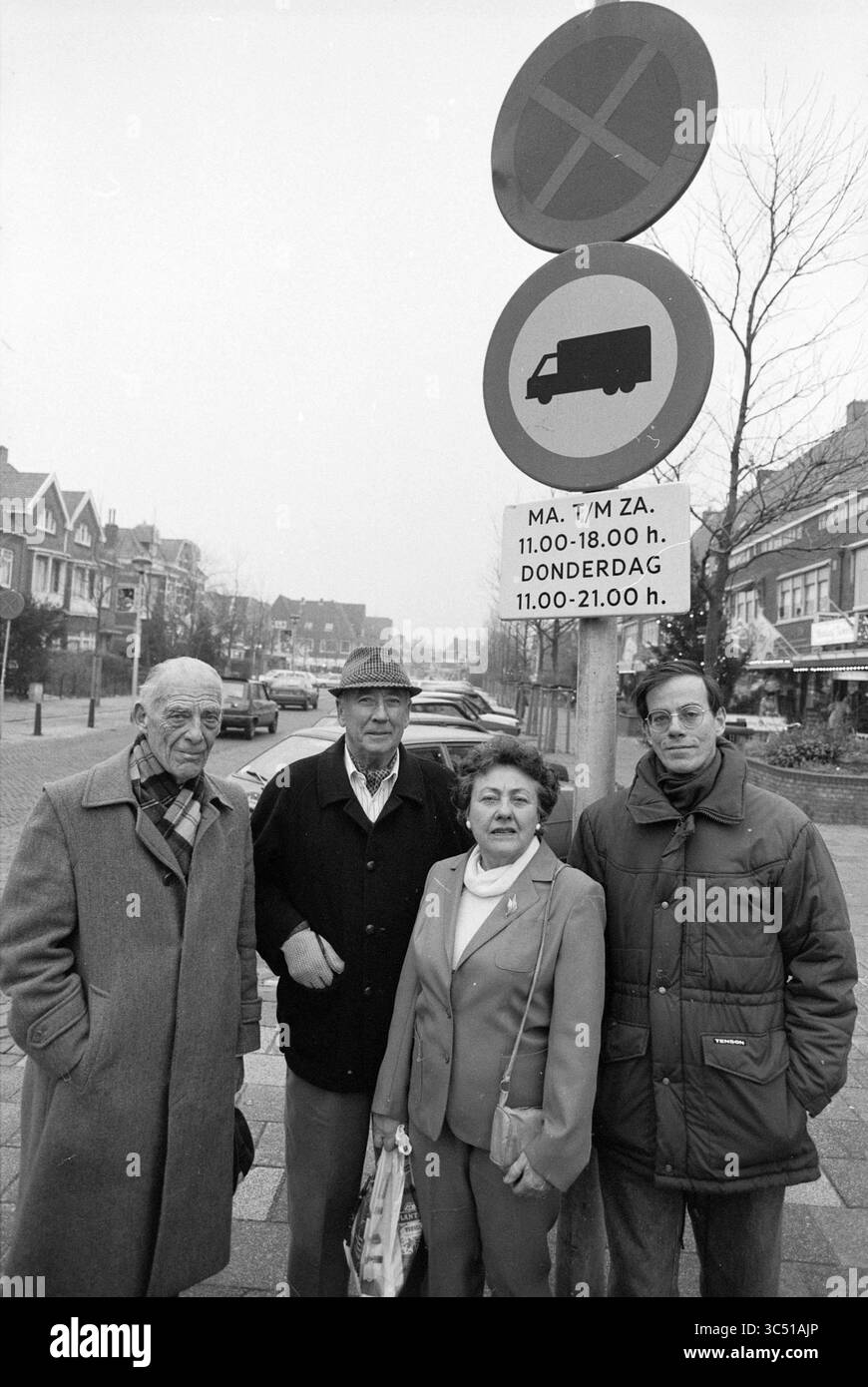Quatre personnes d'un groupe de trafic sur Binnenweg Heemstede, Binnenweg, 04-01-1990 Whizgle News, Dutch Desk, pays-Bas, 1950-2000 Un groupe de quatre personnes se tient près d'un panneau indiquant les restrictions de stationnement et les heures d'ouverture des camions. Ils semblent être en milieu urbain, entourés de magasins et de véhicules. Les gens sont habillés en vêtements d'hiver, et l'atmosphère suggère une journée calme. Banque D'Images