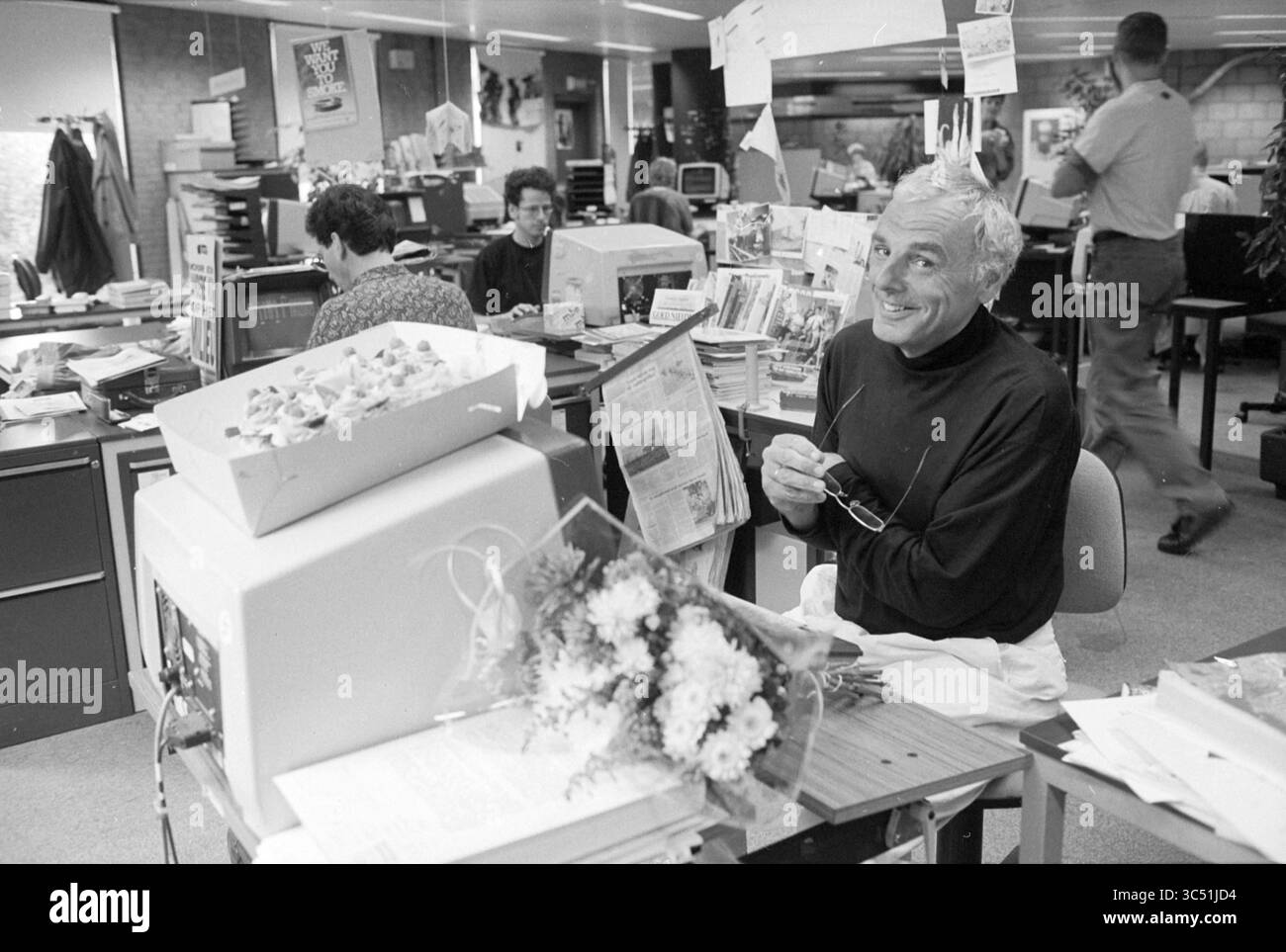 Rob van de Dobbelstein éd. Hoofddorp, Hoofddorp, pays-Bas, 29-09-1992 Whizgle News, Dutch Desk, les pays-Bas, 1950-2000 Une scène de bureau occupée mettant en scène plusieurs personnes engagées dans diverses tâches. Un homme sourit à la caméra alors qu'il était assis à son bureau encombré, orné de fleurs et de papiers. En arrière-plan, les employés se concentrent sur leur travail dans un environnement de travail animé. Banque D'Images