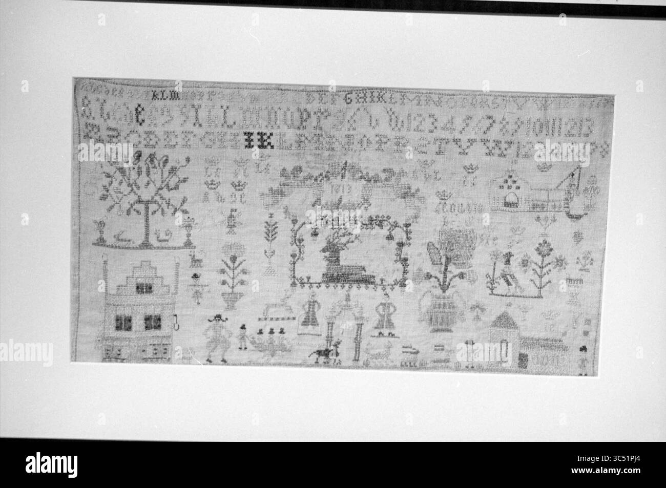 Échantillonneurs, Beeckestijn, 15-12-1996 Whizgle News, Dutch Desk, pays-Bas, 1950-2000 Une pièce textile détaillée présentant des motifs complexes, des lettres et des motifs tels que des arbres, des maisons et divers éléments décoratifs, mettant en valeur l'artisanat et le design artistique d'une époque passée. Banque D'Images