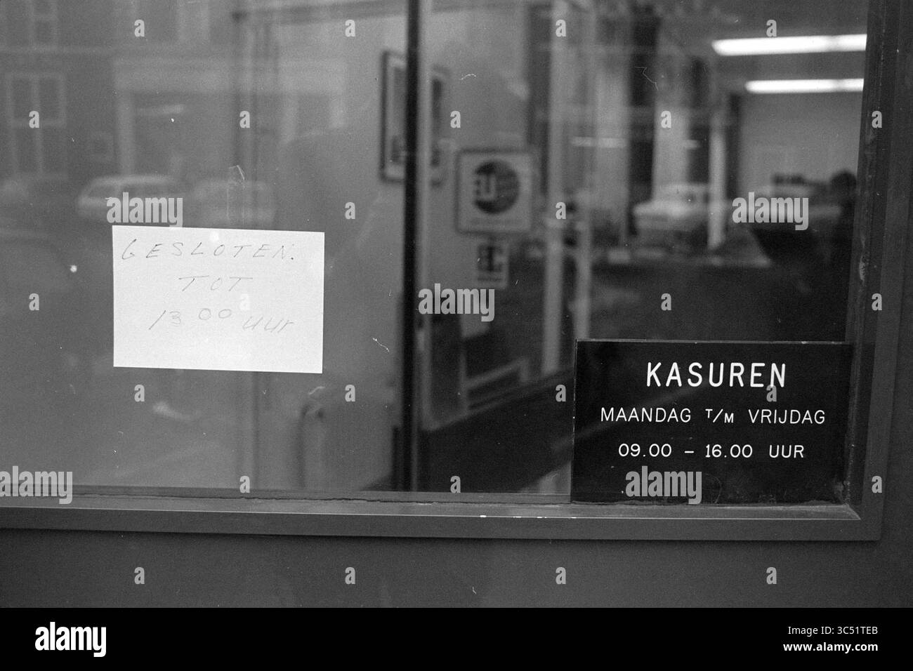 International Et ext. Boerenleenbank, Haarlem, Gedempte Oude Gracht, pays-Bas Whizgle News, Dutch Desk, pays-Bas, 1950-2000 Une porte de magasin est munie d'un panneau manuscrit indiquant qu'elle est fermée jusqu'à 13 h. À proximité, une plaque de verre affiche les heures d'ouverture des jours de semaine, indiquant qu'ils sont ouverts de 9 h à 16 h. Banque D'Images