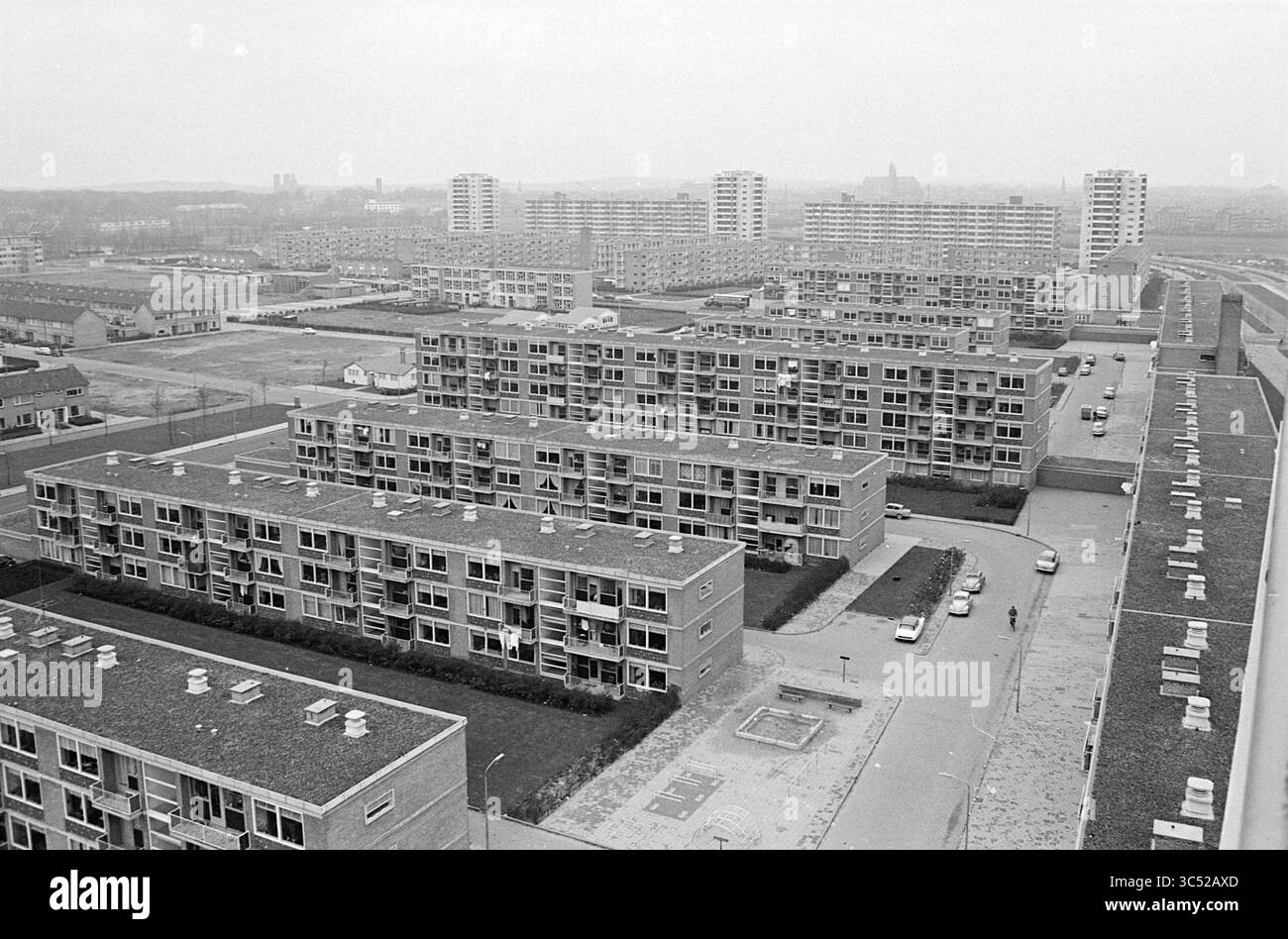 Aperçu des activités Schalkwijk, activités, 11-11-1965 Whizgle News, Dutch Desk, pays-Bas, 1950-2000 Un paysage urbain tentaculaire avec des grappes de bâtiments résidentiels de faible hauteur, avec des rangées d'appartements réparties entre des espaces ouverts et des véhicules. La scène met en valeur un mélange de styles architecturaux et un sentiment de communauté dans un environnement urbain, encadré par des gratte-ciel lointains. Banque D'Images
