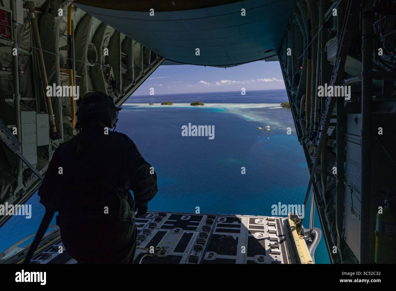 8 décembre 2019 - Guam - L'aviateur principal Lauren Shaw, maître de chargement du 36e escadron de transport aérien de la base aérienne de Yokota, au Japon, regarde un largage de paquet à faible coût et basse altitude dans le cadre de l'opération Christmas Drop 2019 à la base aérienne d'Andersen, Guam, Dec. 8, 2019. Dans sa 68e année, OCD est la mission de formation au largage aérien la plus longue de worldâ€ ™, fournissant des fournitures essentielles à 56 îles micronésiennes, impactant environ 20 000 personnes sur 1,8 millions de miles nautiques carrés de zone d'opération. (Crédit image : © U.S. Air Force/ZUMA Wire/ZUMAPRESS.com) Banque D'Images