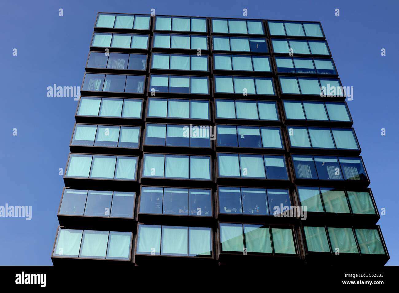 Terrace Tower à Amsterdam présente une grille géométrique de fenêtres en verre contre le ciel clair, capturant l'architecture moderne avec des reflets urbains élégants. Banque D'Images