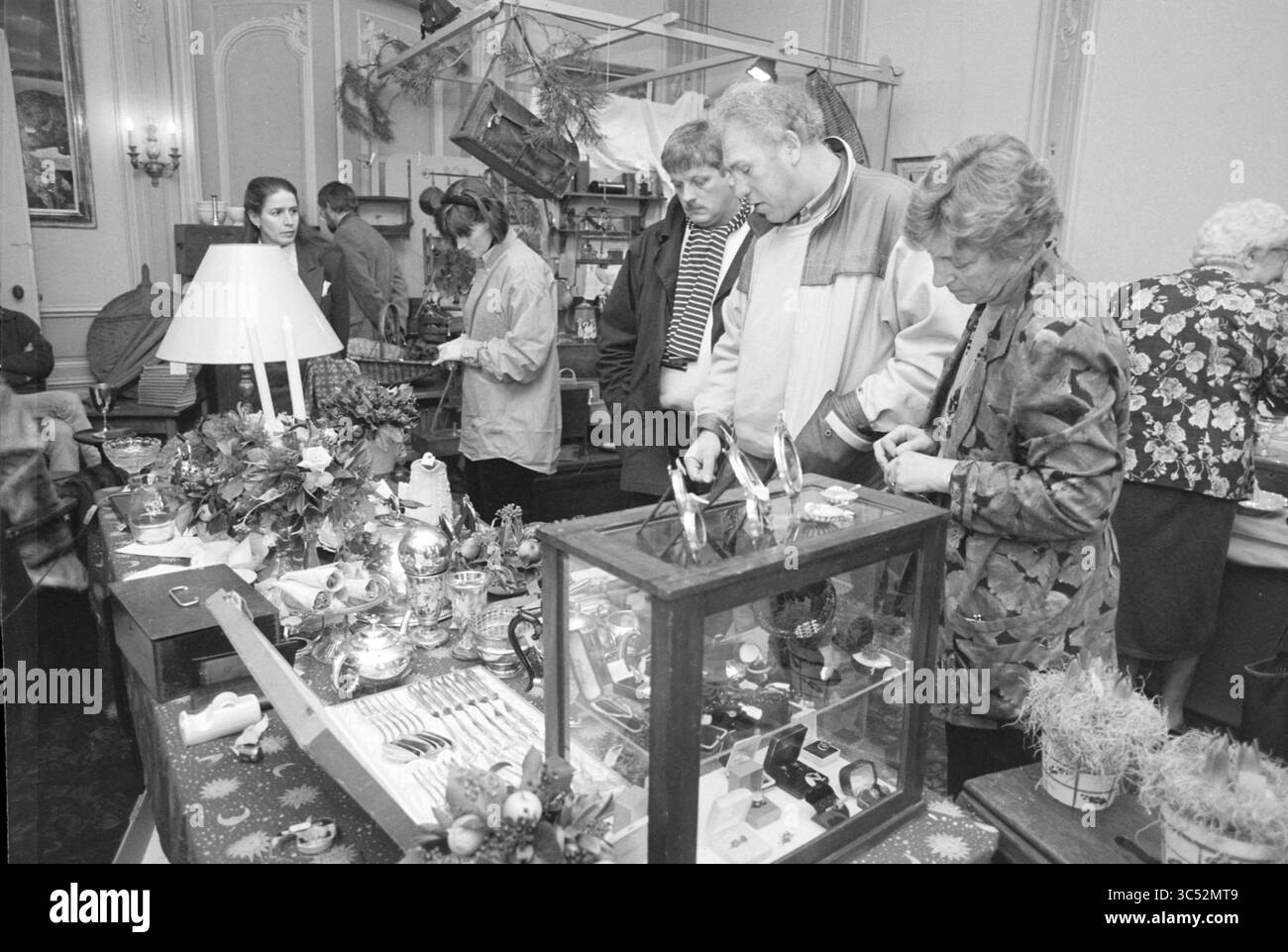 Foire aux antiquités, Waterland, Velsen-Zuid, Velsen-Zuid, 29-11-1996 Whizgle News, Dutch Desk, pays-Bas, 1950-2000 Une scène de marché animée où les gens naviguent à travers une variété d'objets artisanaux et décoratifs faits à la main, examinant des bijoux et d'autres trésors uniques tout en s'engageant dans la conversation les uns avec les autres. Banque D'Images