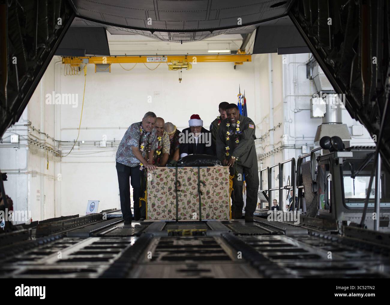9 décembre 2019, Agafo Gumas, Guam, États-Unis : L'ambassadeur des États-Unis aux États fédérés de Micronésie, Robert Riley, Col. Matthew Nicholson, vice-commandant de la 36e Escadre, Col. Otis Jones, commandant de la 374e Escadre de transport aérien, et d'autres font la poussée cérémonielle de la première palette pour lancer l'opération Christmas Drop à Andersen Air Force base le 9 décembre 2019 à Agafo Gumas, Guam. Au cours des 68 dernières années, l'opération Christmas Drop de l'armée de l'air américaine a fourni des fournitures essentielles à 56 îles micronésiennes, touchant environ 20 000 personnes dans une zone de 1,8 millions de milles marins carrés Banque D'Images
