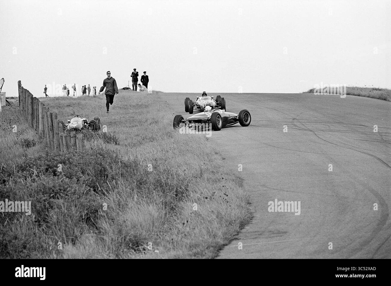 Course automobile N.A.V. sur le circuit de Zandvoort, circuit Zandvoort, Zandvoort, 01-09-1963 Whizgle News, Dutch Desk, pays-Bas, 1950-2000 Une voiture de course suit un virage sur une piste, les spectateurs au loin observant l'action. Une autre voiture est partiellement visible hors de la piste, suggérant un moment de drame pendant l'épreuve de course. Banque D'Images