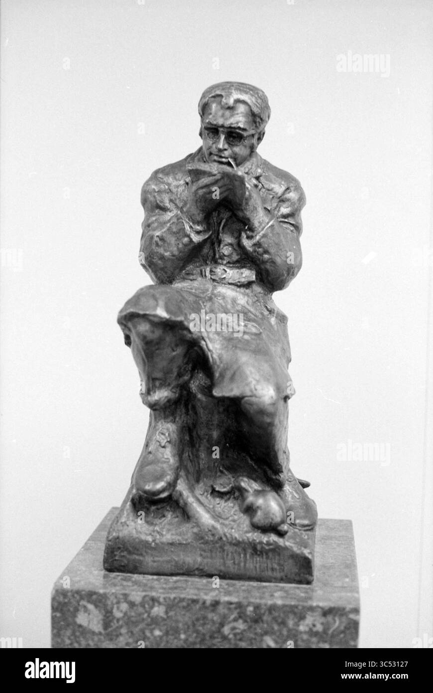 Image de Godfried Bomans Whizgle News, Dutch Desk, pays-Bas, 1950-2000 Une figure contemplative est assise les mains serrées près du menton, dégageant un sentiment d'introspection. La sculpture capture des détails complexes des vêtements et des expressions faciales, tandis qu'un petit animal se repose à la base, ajoutant une touche de chaleur à la scène. Banque D'Images