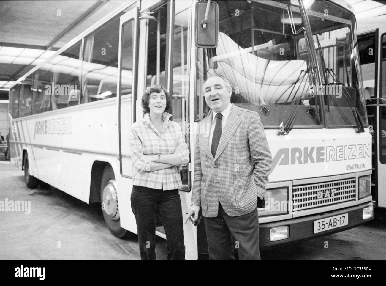 Report Arke Travel Enschede, Travel, Report, 22-11-1978 Whizgle News, Dutch Desk, pays-Bas, 1950-2000 Un homme en costume se tient à côté d'une femme portant une chemise à carreaux, tous deux souriant devant un grand bus de passagers étiqueté 'ARKE REIZEN'. Le paramètre semble être un terminal d'autobus ou un garage. Banque D'Images