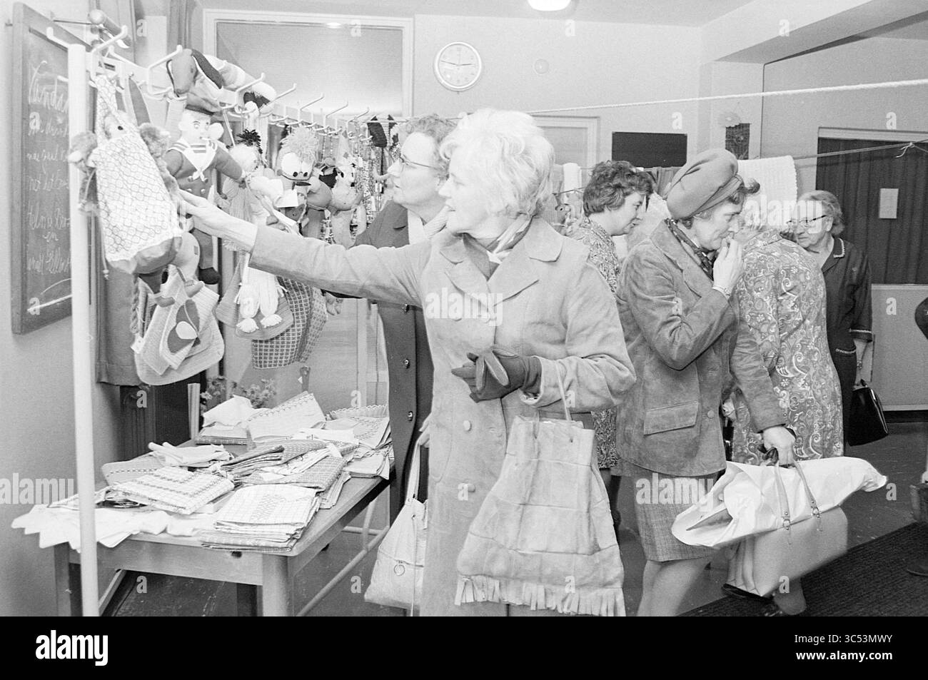 Vente de textiles dans une maison de soins infirmiers Whizgle News, Dutch Desk, pays-Bas, 1950-2000 Un groupe de femmes parcourent des objets artisanaux et textiles artisanaux lors d'un événement communautaire, examinant divers articles exposés sur des étagères tout en discutant. Banque D'Images Vente de textiles dans une maison de soins infirmiers Whizgle News, Dutch Desk, pays-Bas, 1950-2000 Un groupe de femmes parcourent des objets artisanaux et textiles artisanaux lors d'un événement communautaire, examinant divers articles exposés sur des étagères tout en discutant. Banque D'Images