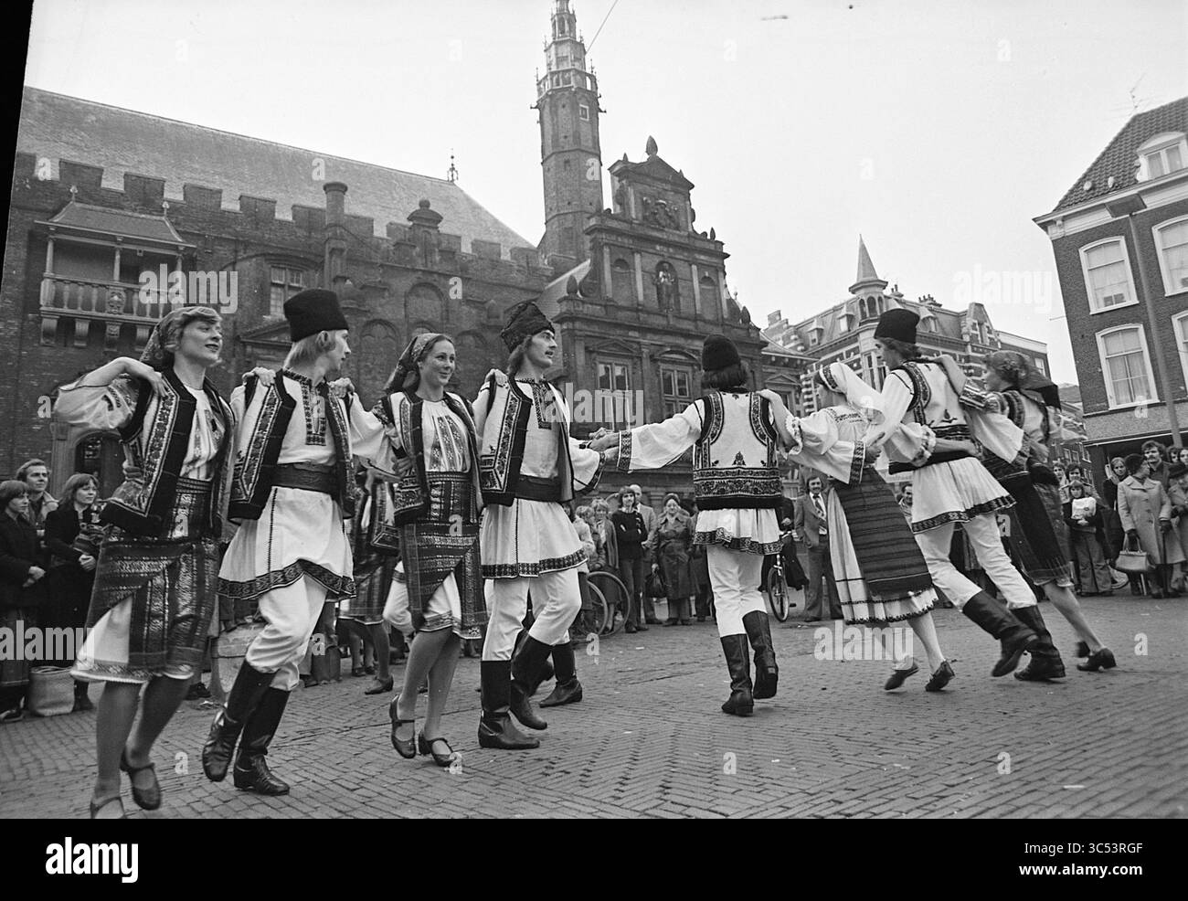 Danseurs, danseurs yougoslaves et mariage, danse, 17-10-1975 Whizgle News, Dutch Desk, pays-Bas, 1950-2000 Un spectacle de danse traditionnelle dynamique occupe le devant de la scène, mettant en vedette des danseurs dans des costumes élaborés. Ils se déplacent gracieusement, incarnant le patrimoine culturel, tandis qu'un public regarde avec un vif intérêt dans un contexte d'architecture historique. Banque D'Images