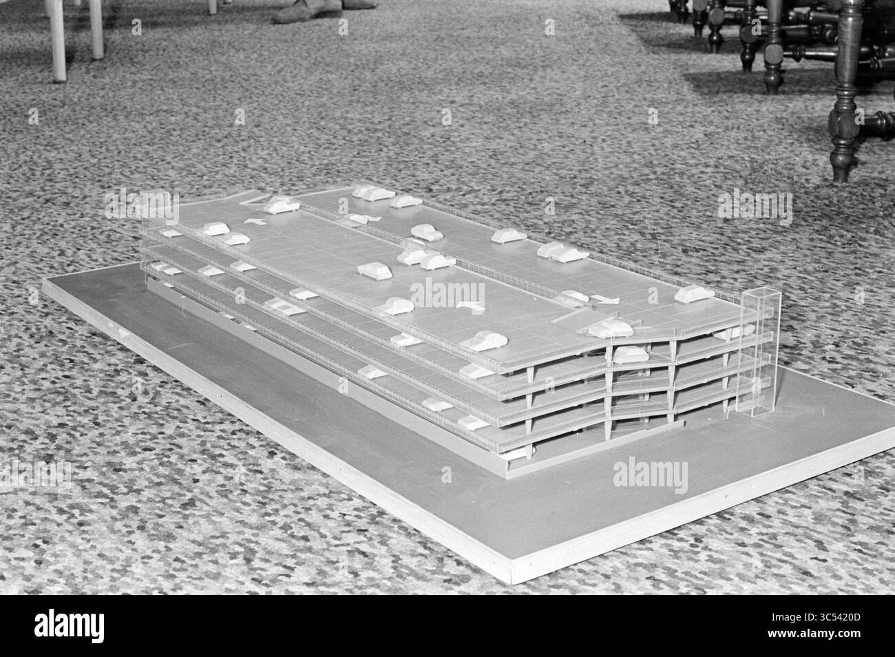 Modèle de parking garage., modèle, 21-01-1970 Whizgle News, Dutch Desk, pays-Bas, 1950-2000 Un modèle architectural détaillé d'une structure de stationnement à plusieurs niveaux, présentant des emplacements de voiture réalistes et une base texturée, affichée sur une surface à motifs. Banque D'Images