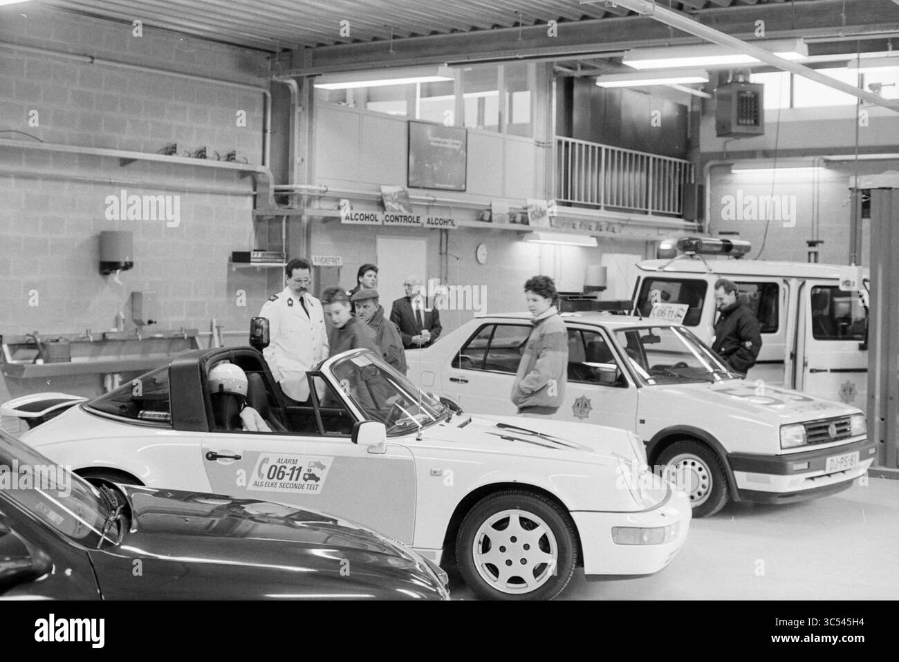 Journée portes ouvertes à la police à Hoofddorp, Hoofddorp, pays-Bas, 06-02-1992 Whizgle News, Dutch Desk, pays-Bas, 1950-2000 Un groupe de personnes se réunit dans un atelier automobile, s'entretenant avec divers véhicules, y compris une voiture de sport élégante et un modèle compact. L'atmosphère reflète un mélange de concentration et d'excitation, probablement centré autour d'un rallye automobile ou d'un événement de sport automobile. Quelques personnes sont en conversation, tandis que d'autres inspectent les voitures, mettant en valeur une culture automobile dynamique. Banque D'Images