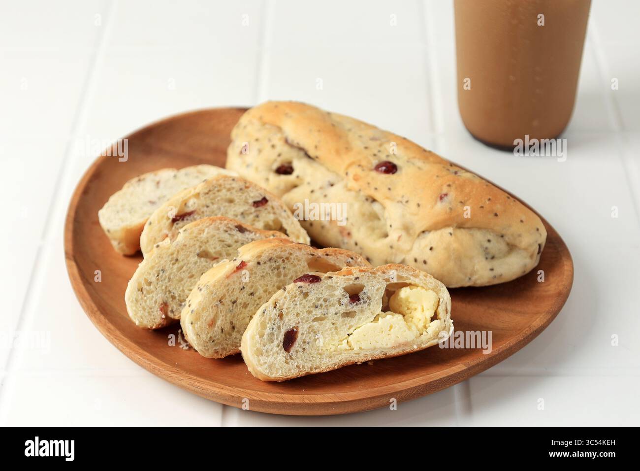 Pain roti Macan tranché, fromage à la canneberge Sourdough servi sur une assiette en bois avec une tasse de café Banque D'Images