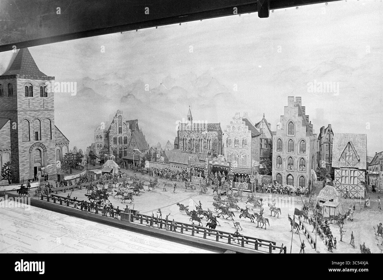 Exposition villes cabinets, expositions, 15-06-1967 Whizgle News, Dutch Desk, pays-Bas, 1950-2000 Une scène miniature détaillée représentant une place médiévale animée, présentant une variété de styles architecturaux dans les bâtiments, des figures animées à cheval, et un sentiment d'activité communautaire dans un cadre historique. La toile de fond comprend des montagnes lointaines, ajoutant de la profondeur au paysage. Banque D'Images