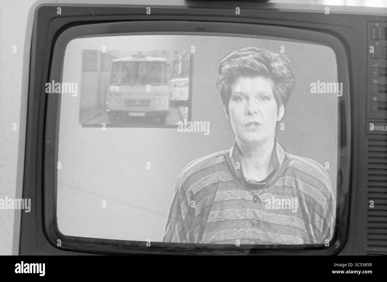 Maartje van Weegen nos news, télévision, 26-07-1988 Whizgle News, Dutch Desk, pays-Bas, 1950-2000 Un présentateur de nouvelles livre un reportage, avec un graphique d'un véhicule en arrière-plan. L'ancre semble ciblée et professionnelle, présentant l'information clairement à l'auditoire. Banque D'Images