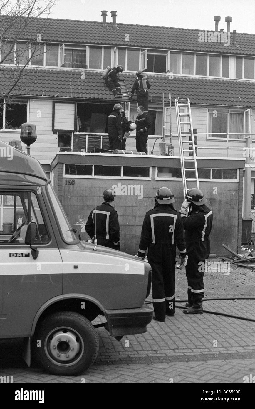 Brand, Vronen, Nouveau. Vennep, Nieuw-Vennep, Vronen, 26-02-1991 Whizgle News, Dutch Desk, pays-Bas, 1950-2000 Un groupe de pompiers intervient en cas d'urgence, travaillant ensemble pour sauver des personnes d'un bâtiment. Certains membres de l'équipe sont positionnés sur un toit, tandis que d'autres coordonnent à partir du sol à côté d'un camion de pompiers. Banque D'Images