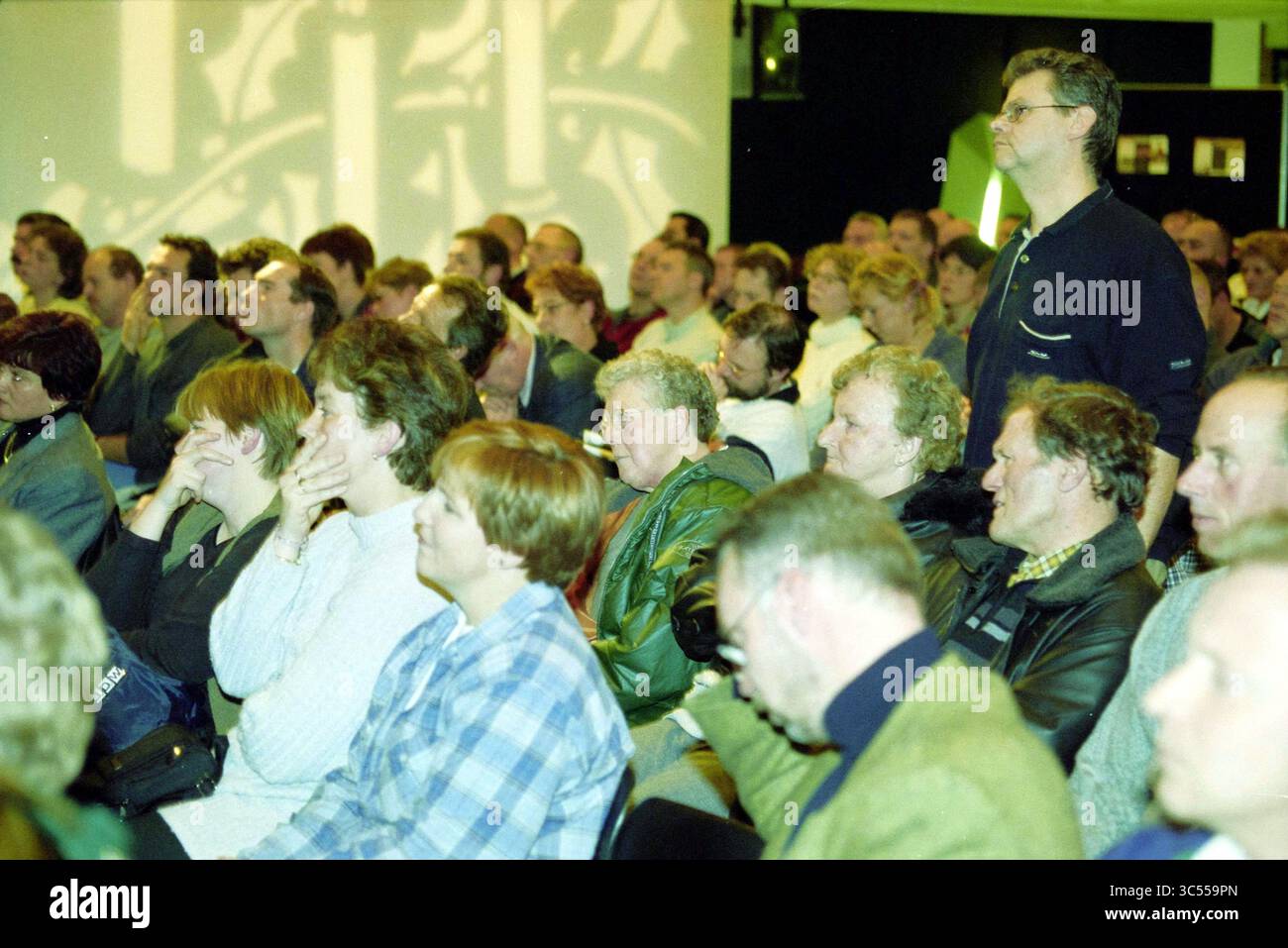 Soirée d'information pour les demandeurs d'asile à Hoofddorp, Hoofddorp, pays-Bas, 17-12-2000 Whizgle News, Dutch Desk, pays-Bas, 1950-2000 Un groupe diversifié d'individus écoute attentivement pendant un événement, certains profondément dans la pensée tandis que d'autres semblent engagés dans la conversation. L'atmosphère suggère un rassemblement pour discussion ou présentation, avec diverses expressions reflétant la concentration et l'intérêt. Banque D'Images