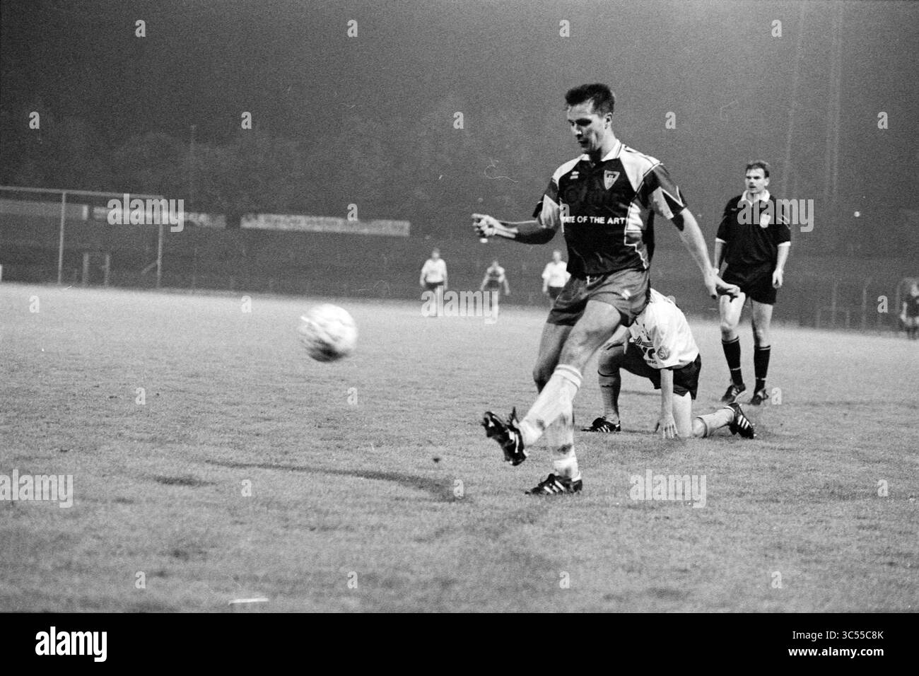 Haarlem - Veendam, 25-09-1992 Whizgle News, Dutch Desk, pays-Bas, 1950-2000 Un joueur de football frappe habilement le ballon pendant un match, avec un défenseur au sol à proximité et un arbitre supervisant l'action. Le réglage capture l'intensité et le mouvement dynamique typiques du jeu compétitif. Banque D'Images