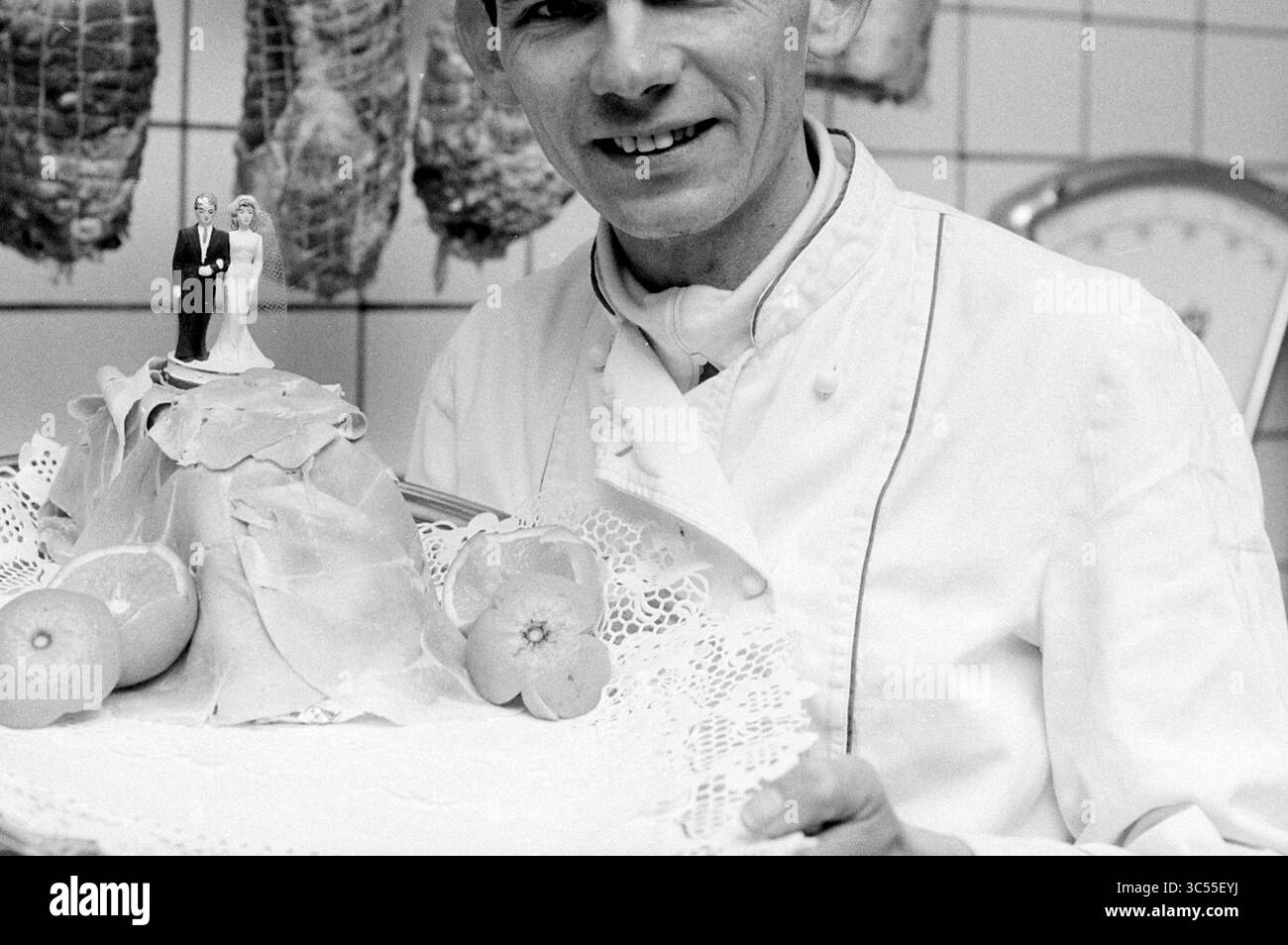 Mr. Prooie, restauration Overveen, Overveen, 23-01-1992 Whizgle News, Dutch Desk, pays-Bas, 1950-2000 Un chef présente fièrement un plat élaboré avec un gâteau de mariage décoratif au sommet d'un monticule de nourriture délicatement arrangée, avec des figurines ludiques d'une mariée et mariée. Les fruits frais sont élégamment exposés à côté du chef-d'œuvre culinaire. Banque D'Images Mr. Prooie, restauration Overveen, Overveen, 23-01-1992 Whizgle News, Dutch Desk, pays-Bas, 1950-2000 Un chef présente fièrement un plat élaboré avec un gâteau de mariage décoratif au sommet d'un monticule de nourriture délicatement arrangée, avec des figurines ludiques d'une mariée et mariée. Les fruits frais sont élégamment exposés à côté du chef-d'œuvre culinaire. Banque D'Images