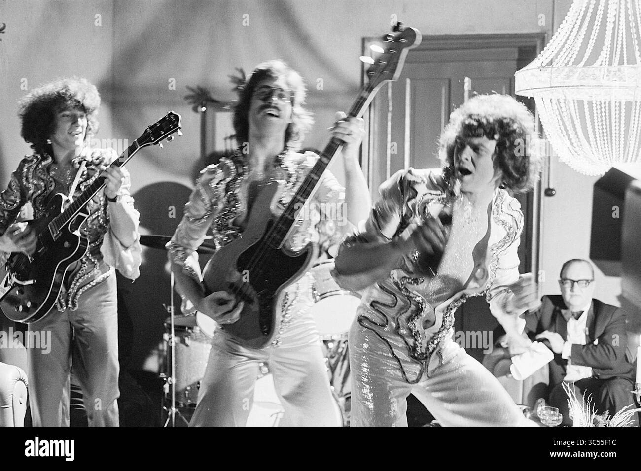 Groupe 'Circus' et Ir. E. van der Pik avec l'enregistrement 'No Beer but Buttermilk' at v. Oekels disco corner of the VPRO', télévision, 27-12-1974 Whizgle News, Dutch Desk, pays-Bas, 1950-2000 Une performance live vibrante met en scène trois musiciens jouant passionnément des instruments sur scène. Vêtues de tenues étincelantes, leur énergie captive le public, tandis qu'un décor élégant rehausse l'atmosphère animée. Banque D'Images