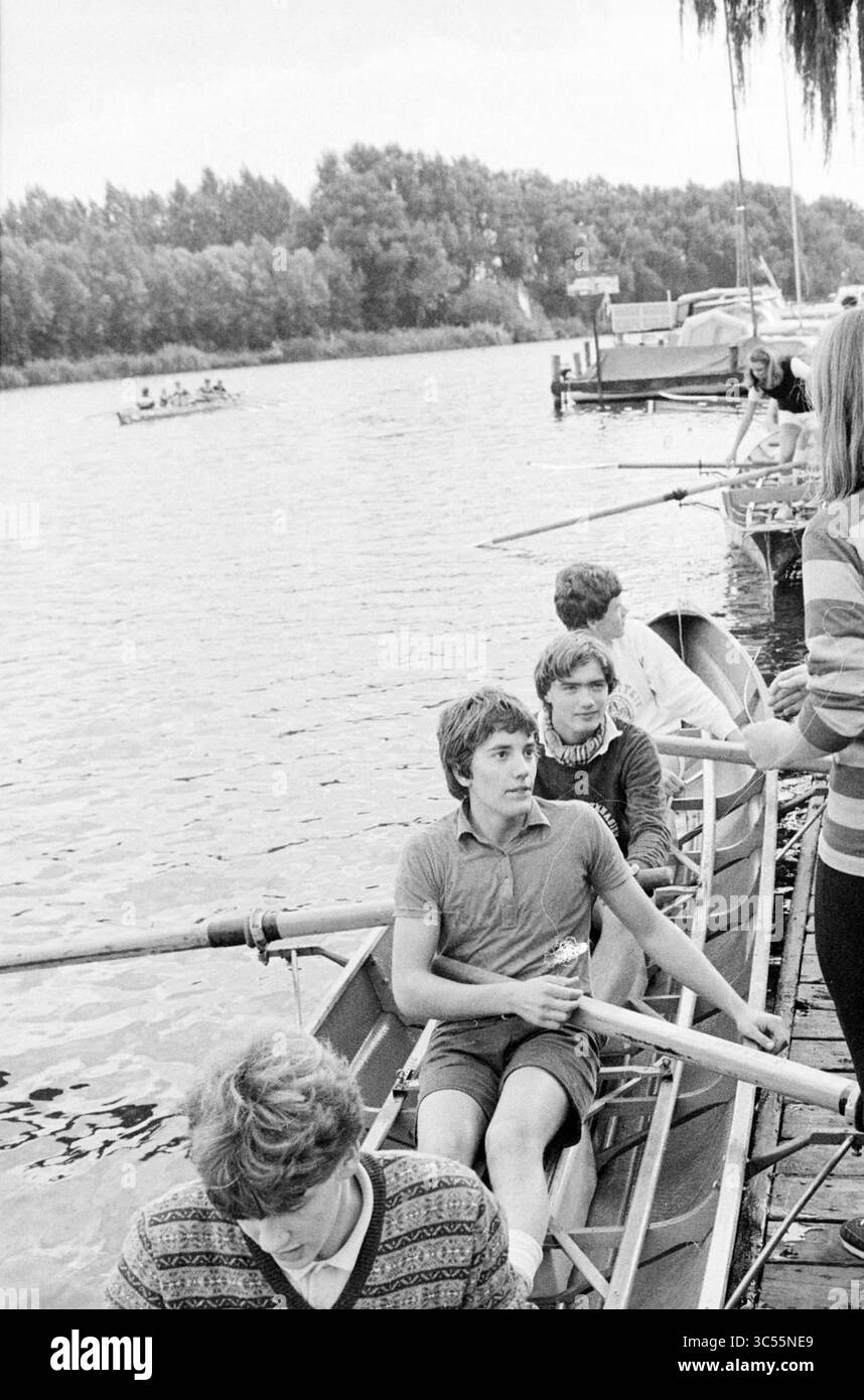 Aviron Spaarne, nouveaux arrivants (Stedelijk Gym), aviron, compétitions d'aviron, etc., 05-10-1980 Whizgle News, Dutch Desk, pays-Bas, 1950-2000 Un groupe de jeunes rameurs se prépare pour une séance d'entraînement au bord de l'eau, avec des bateaux alignés le long du quai et d'autres glissant au loin. Certains membres de l'équipe se concentrent sur leur technique tandis que d'autres s'engagent dans la conversation, illustrant une camaraderie avant de se lancer dans leur aventure d'aviron. Banque D'Images