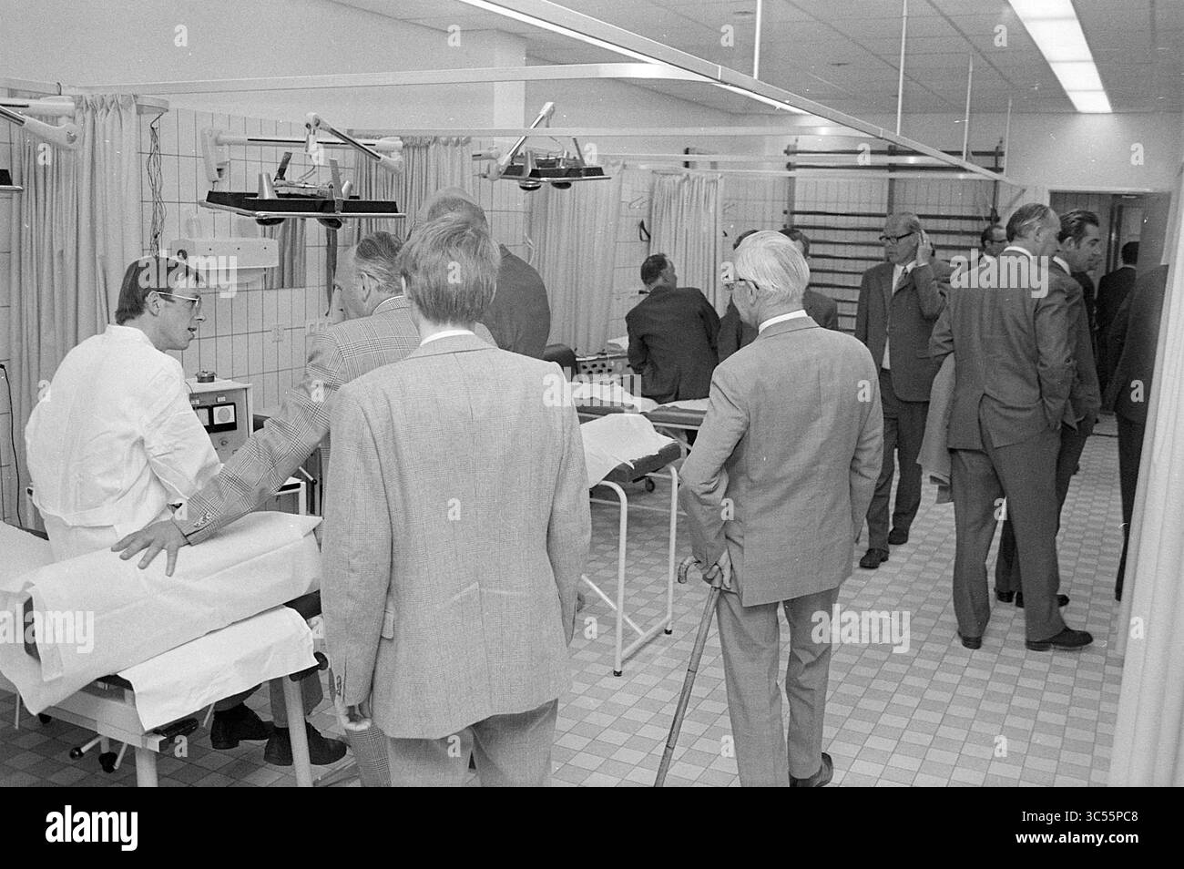 Ouverture du centre médical Hoogovens, ouverture, ouvertures, mise en service, 24-05-1972 Whizgle News, Dutch Desk, pays-Bas, 1950-2000 Un groupe de professionnels en tenue formelle se réunit dans un cadre clinique pour observer ou discuter de diverses procédures et équipements médicaux. L'environnement comprend des lits médicaux, des rideaux pour l'intimité et une gamme de lumières, mettant en évidence l'accent sur les soins de santé et les soins aux patients. Banque D'Images