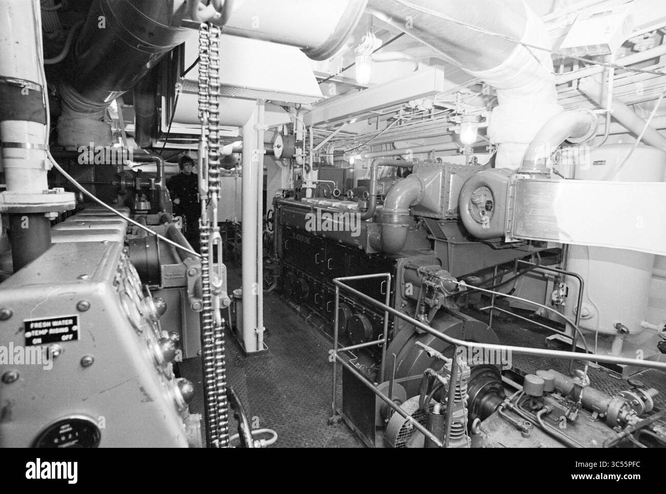 Salle des machines de drague, 00-00-1971 Whizgle News, Dutch Desk, pays-Bas, 1950-2000 vue d'une salle des machines industrielle, avec de grandes machines, des tuyauteries complexes et divers panneaux de commande. L’environnement est rempli de composants mécaniques et d’équipements, reflétant la complexité de l’espace dédié à la production d’électricité ou à la propulsion. Banque D'Images