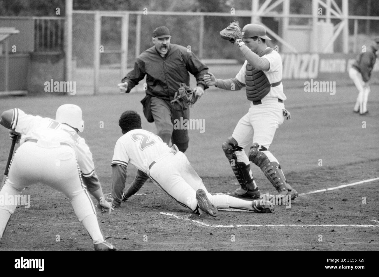 Baseball Nicols - Spartan, 29-06-1991 Whizgle News, Dutch Desk, pays-Bas, 1950-2000 Un moment tendu sur le terrain de baseball alors qu'un joueur glisse dans la plaque d'accueil, essayant d'éviter d'être étiqueté par le receveur, tandis que l'arbitre signale le jeu. L'atmosphère est chargée d'excitation alors que les coéquipiers regardent depuis les lignes de touche. Banque D'Images