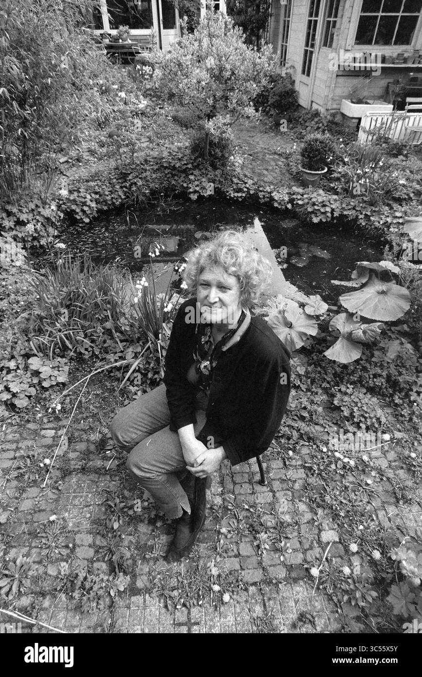 Els Proost, architecte paysagiste, 28-04-1992 Whizgle News, Dutch Desk, pays-Bas, 1950-2000 Une femme aux cheveux bouclés est assise dans un étang de jardin tranquille entouré de verdure luxuriante et de nénuphars, créant une atmosphère sereine. Banque D'Images