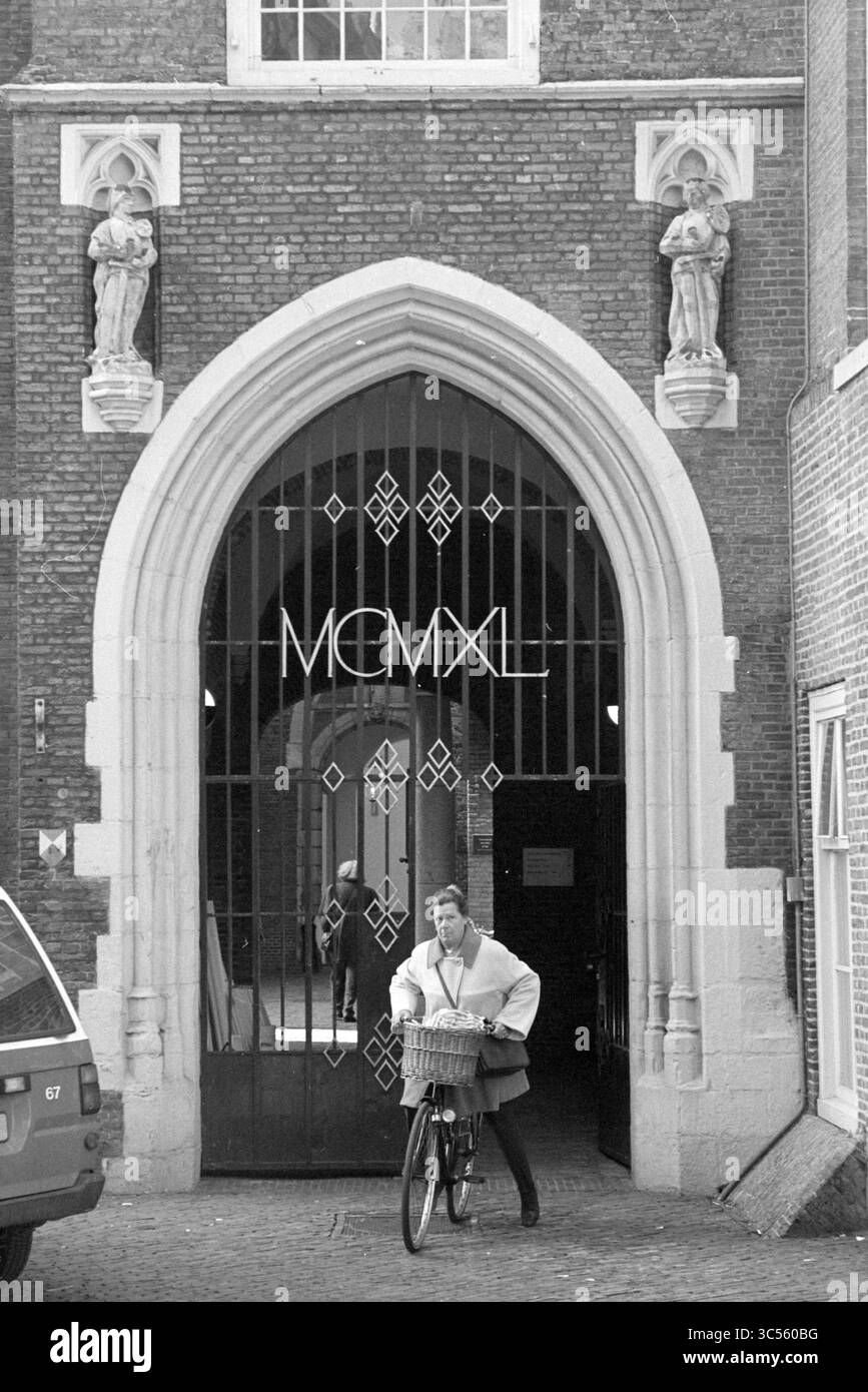 Porte de la mairie, Haarlem, pays-Bas, 23-03-1994 Whizgle News, Dutch Desk, pays-Bas, 1950-2000 Une personne fait du vélo à travers une grande arche ornée d'un design complexe et de statues, tandis que l'année 'MCMLXL' est bien visible au-dessus de l'entrée. Banque D'Images