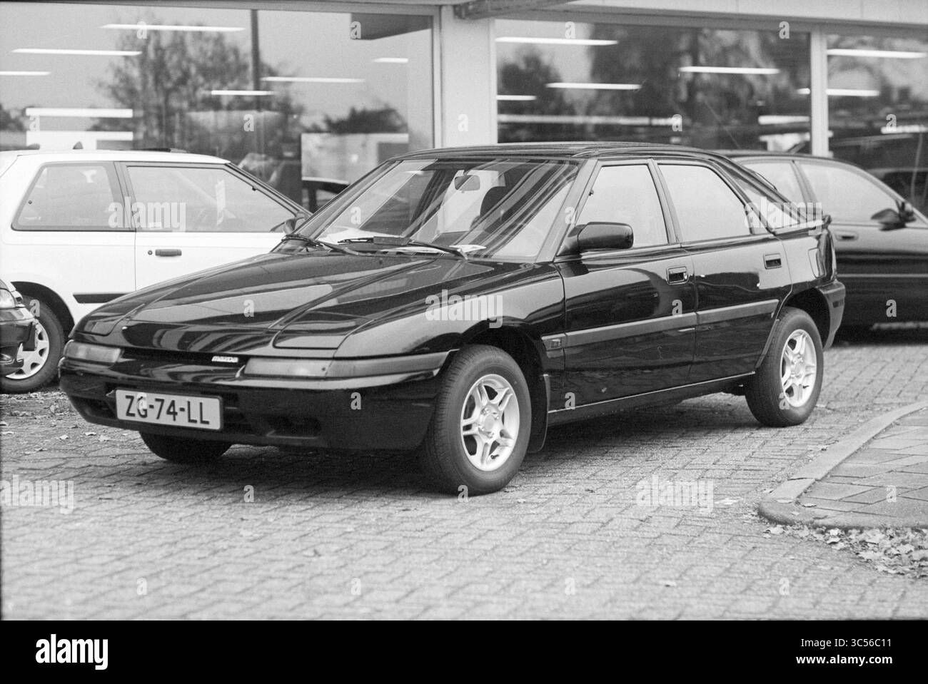 Société automobile Van lent, Heemstede, Heemstede, pays-Bas, 04-11-1997 Whizgle News, Dutch Desk, pays-Bas, 1950-2000 Un élégant hayon noir occupe une place importante, mettant en valeur son design sportif avec des lignes nettes et des jantes en alliage. L'arrière-plan présente d'autres véhicules, faisant allusion à un environnement automobile animé. Une plaque d'immatriculation ajoute une touche de détail à cette voiture élégante. Banque D'Images